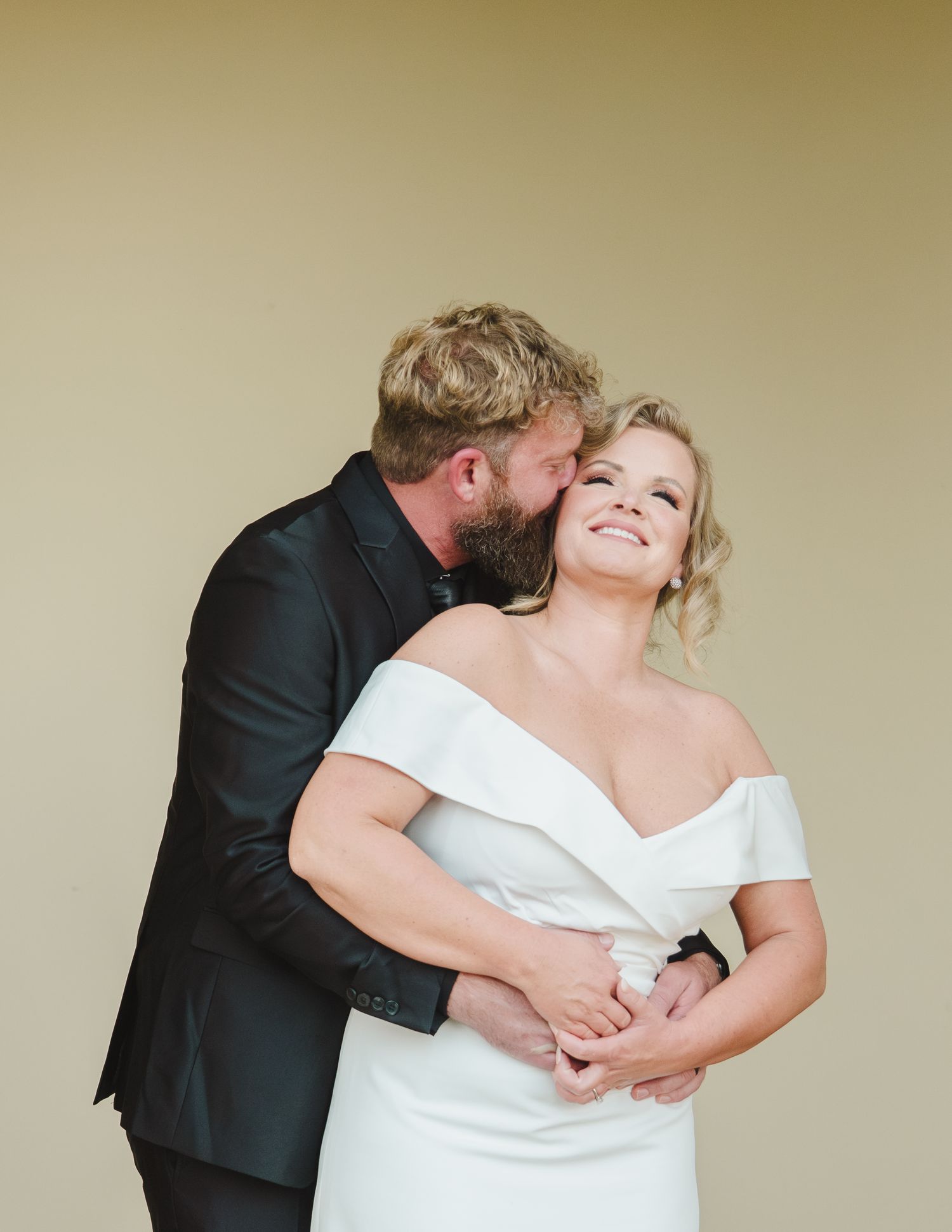 An intimate moment between newlyweds as they embrace and smile during their wedding photoshoot.