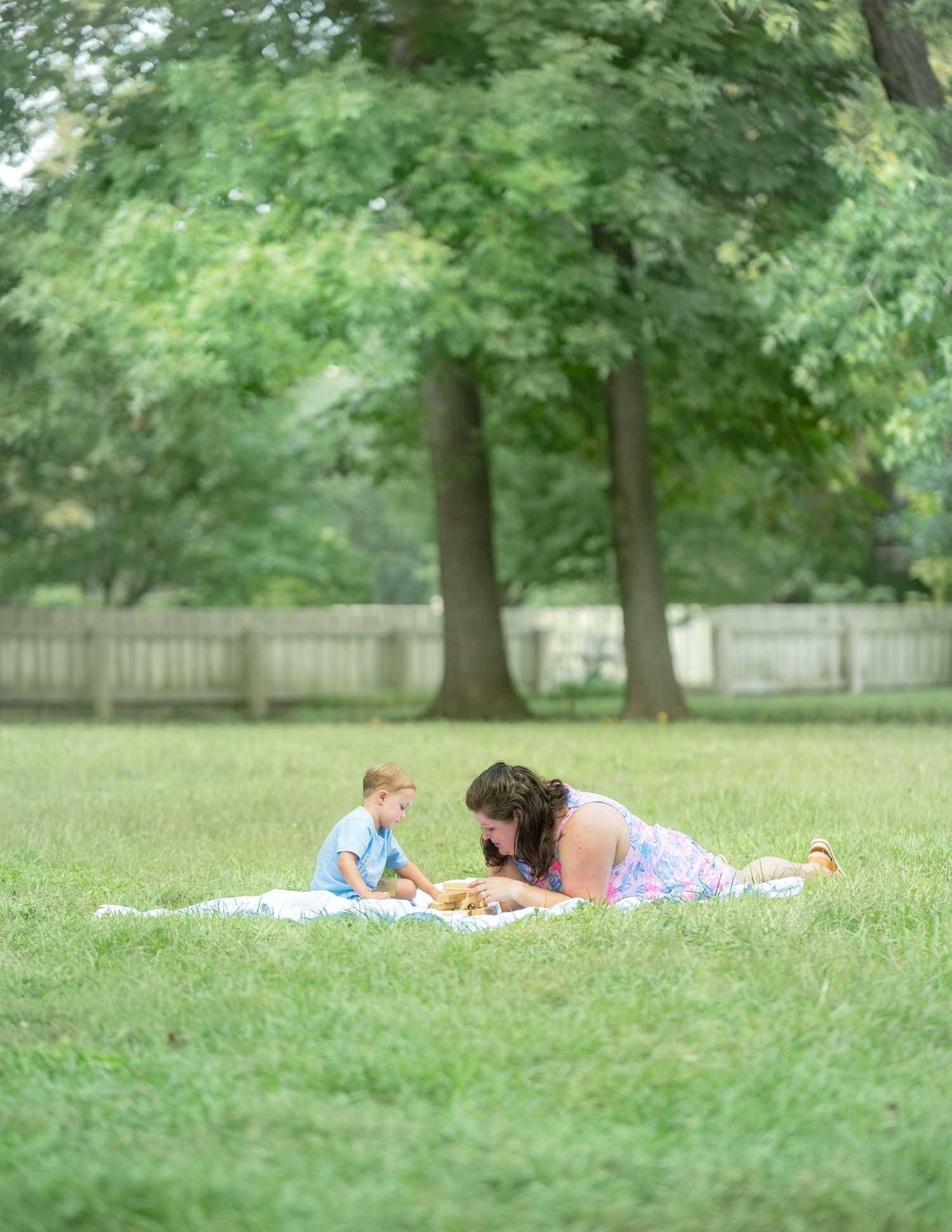 Three photos showing a peaceful summer scene with people lounging and relaxing on green grass under shady trees.