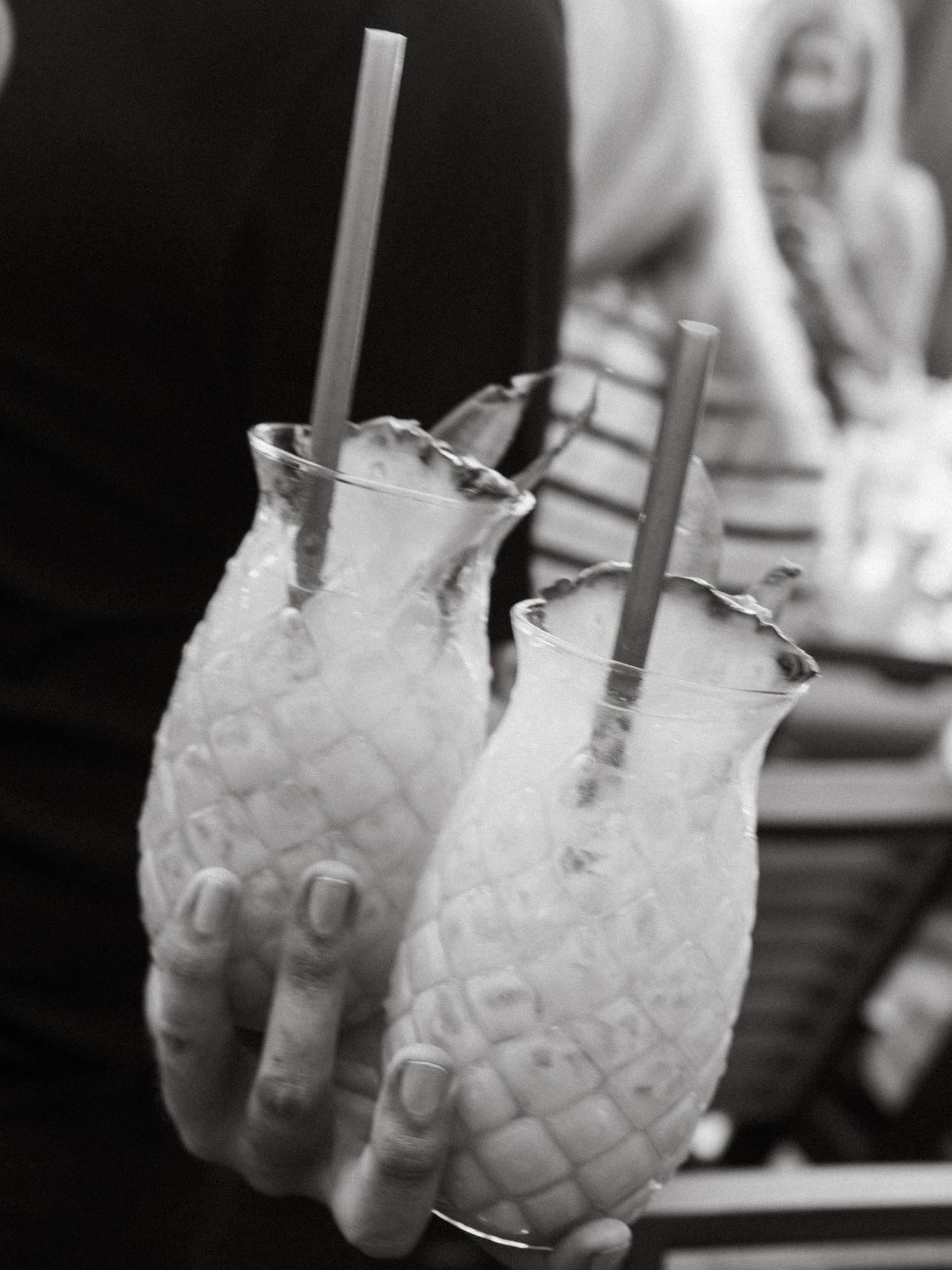 Three frosty tropical cocktails topped with crushed ice and grey straws arranged in a row.