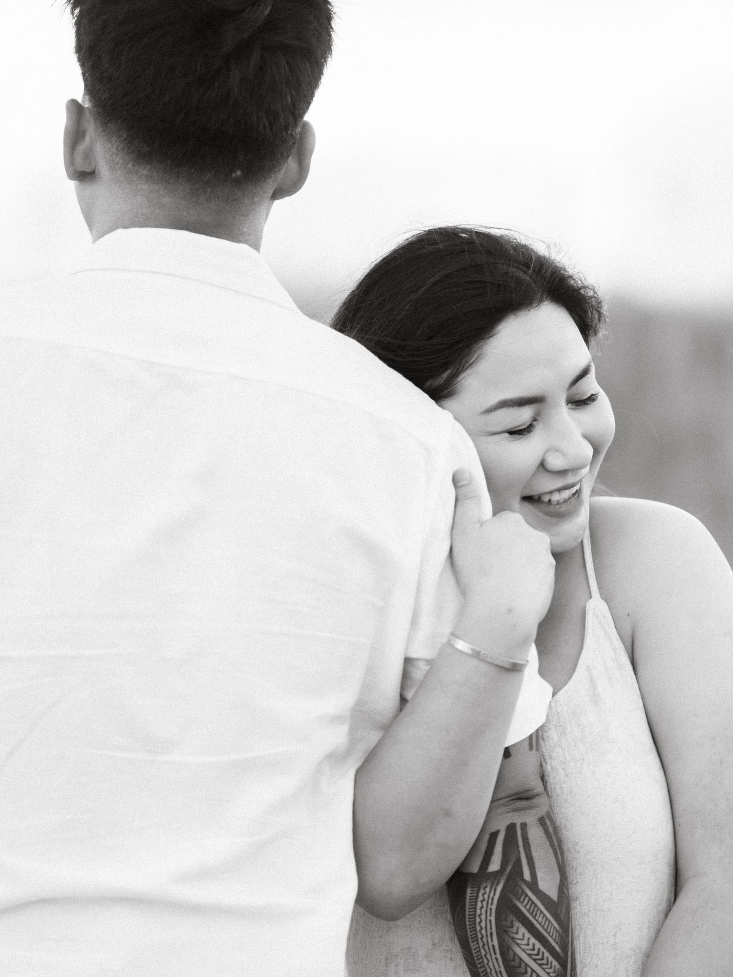 Black and white romantic portrait of a tender couple sharing an intimate moment outdoors.