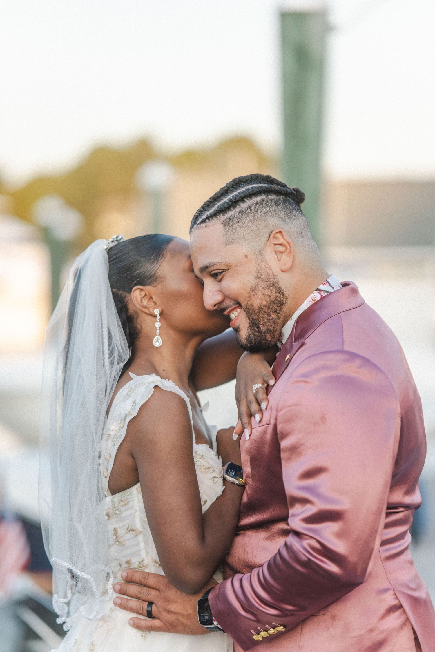 A romantic wedding scene with a couple in pink and white attire sharing blissful moments during their celebration.