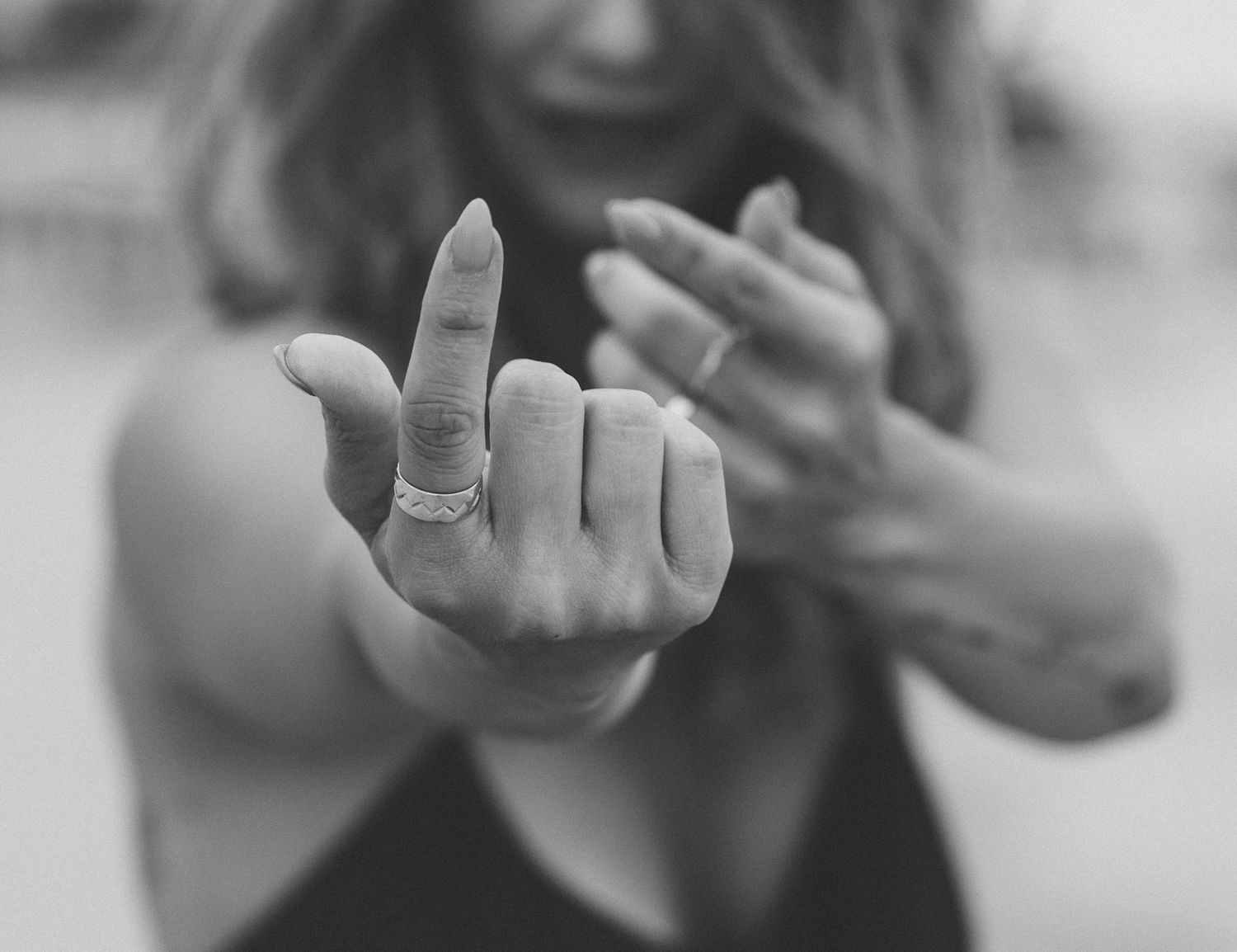 Black and white close-up of hands making a pointed gesture with fingers.