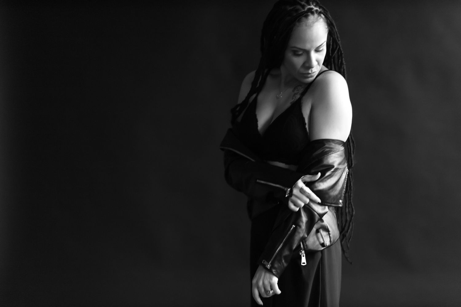 Moody artistic portrait in black and white showing silhouette in flowing dark garments.