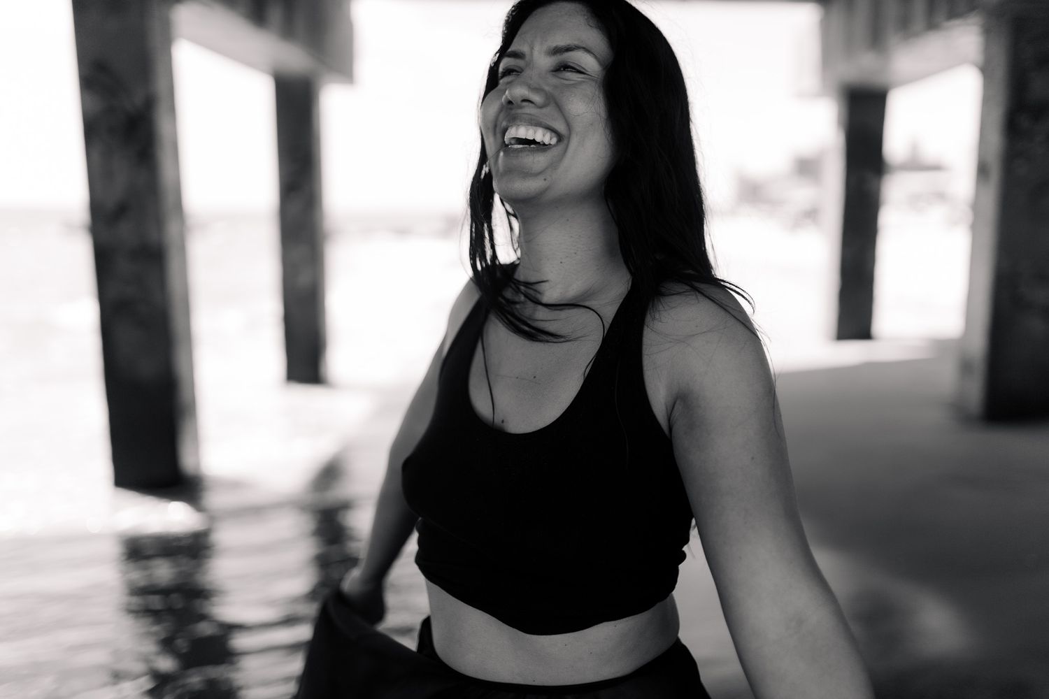 Black and white portrait of someone laughing joyfully in athletic wear.