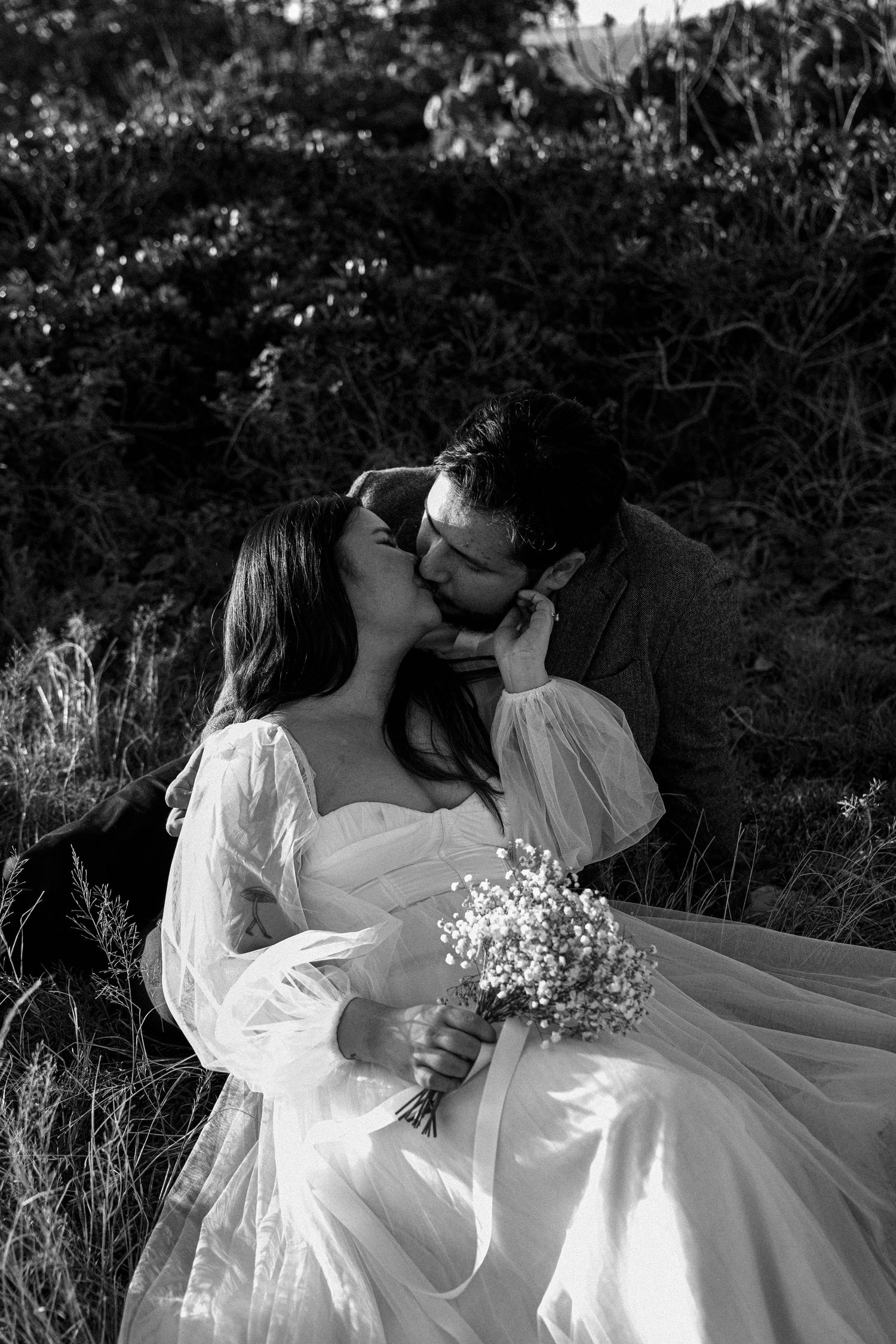 A romantic black and white photo sequence of a couple in wedding attire embracing in a natural outdoor setting.