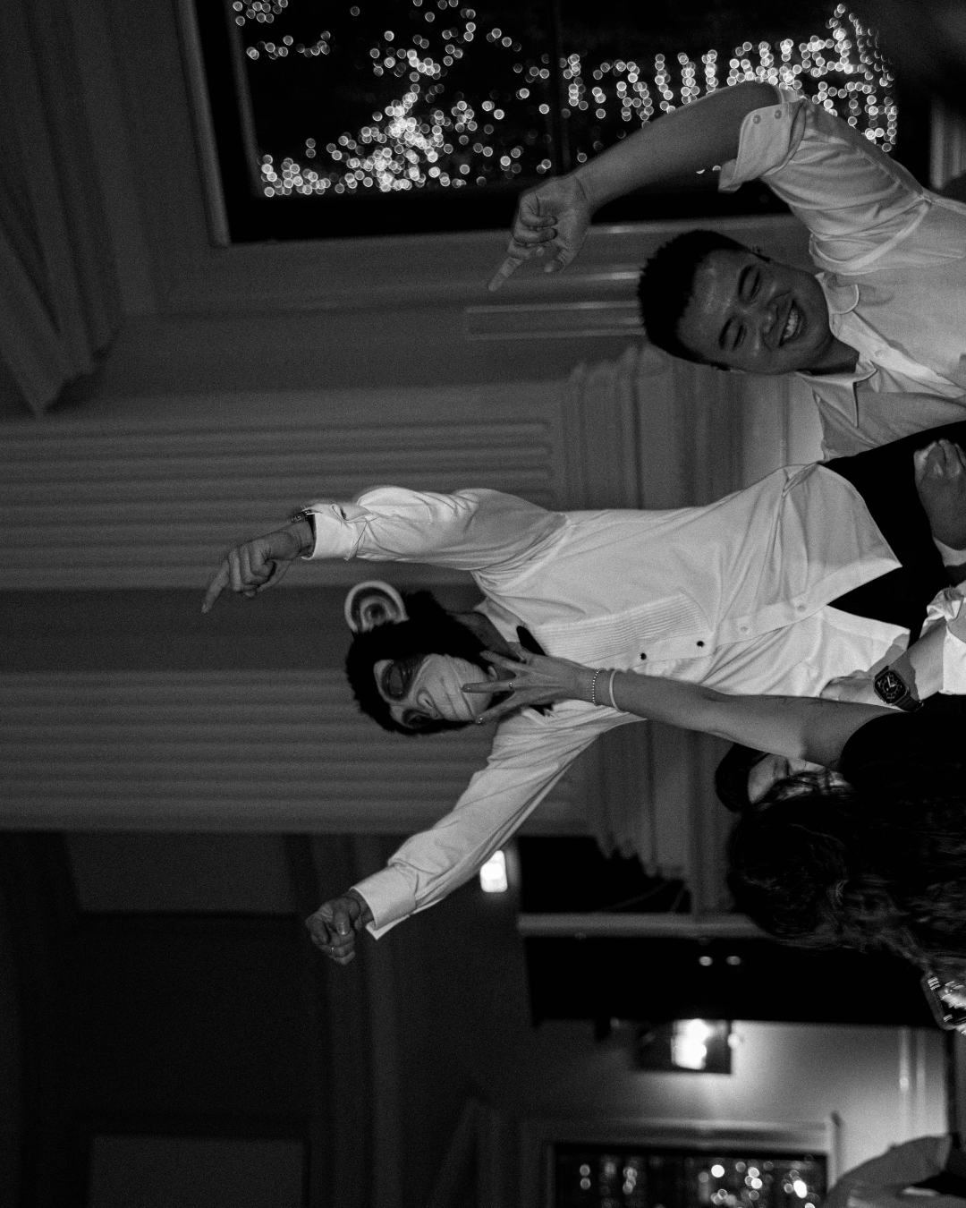 A dramatic black and white photo shows a dancer performing a dynamic movement in white clothing on stage.