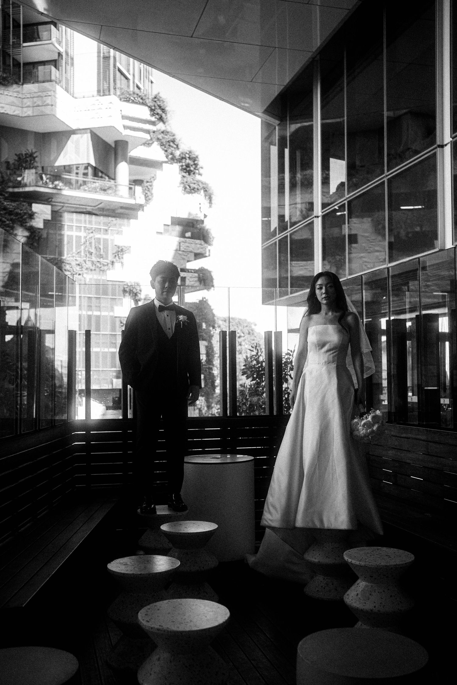 Black and white sequence of silhouettes in a modern building interior with dramatic lighting and reflective surfaces.