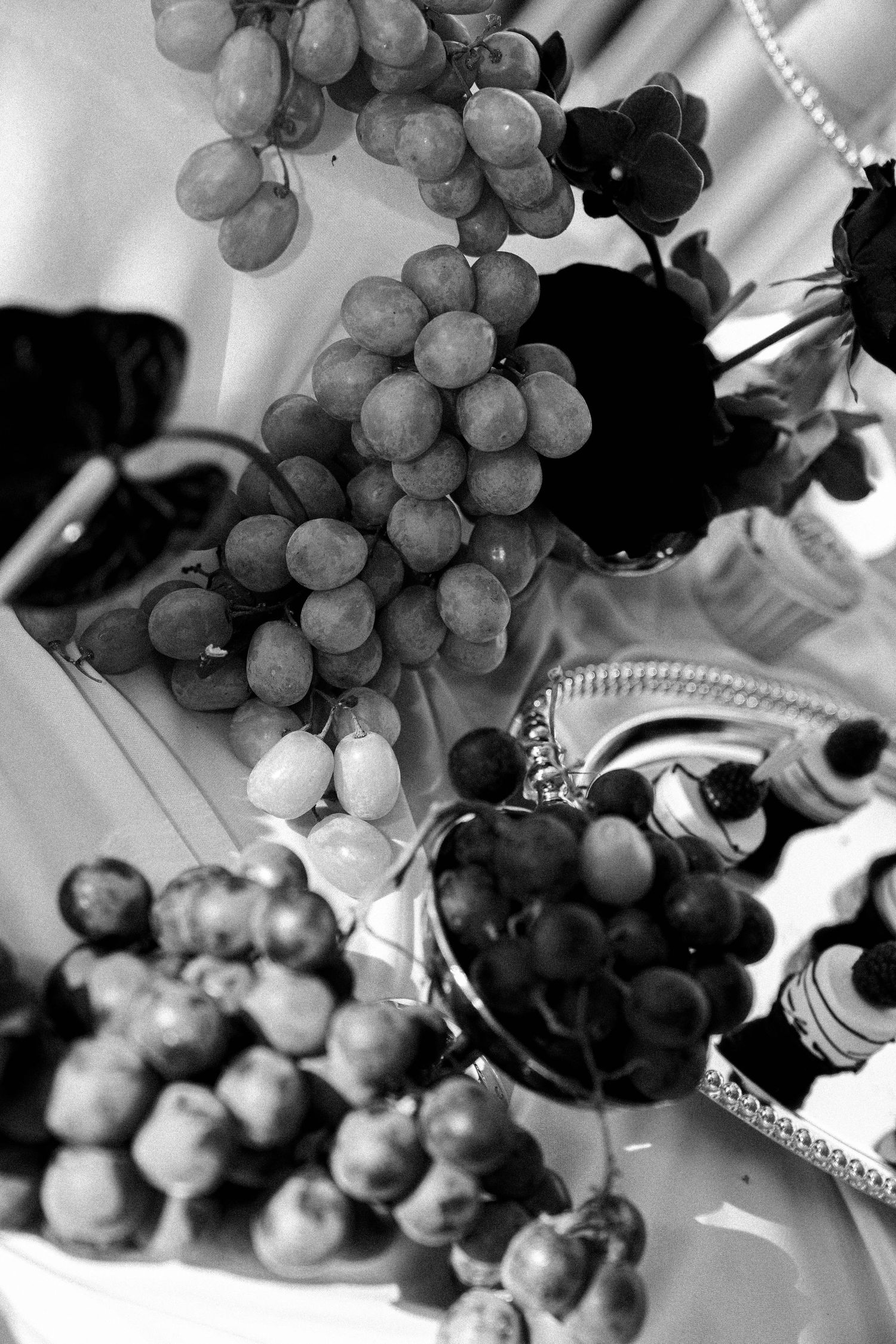 Black and white artistic photographs of ripe grape clusters hanging on vines create an elegant wine-themed composition.
