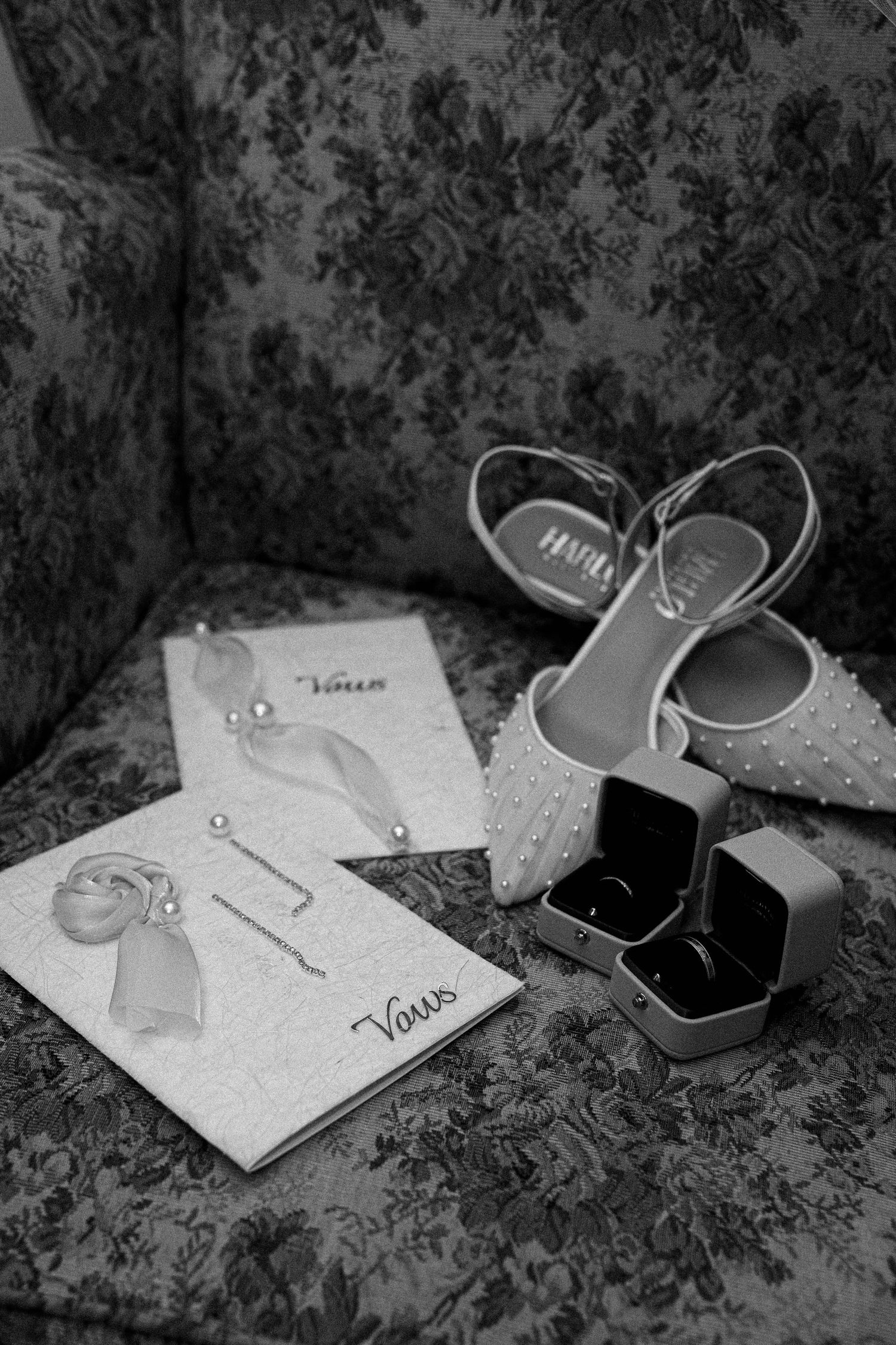 Black and white photo of handwritten notes and shoes arranged artistically on a textured surface.