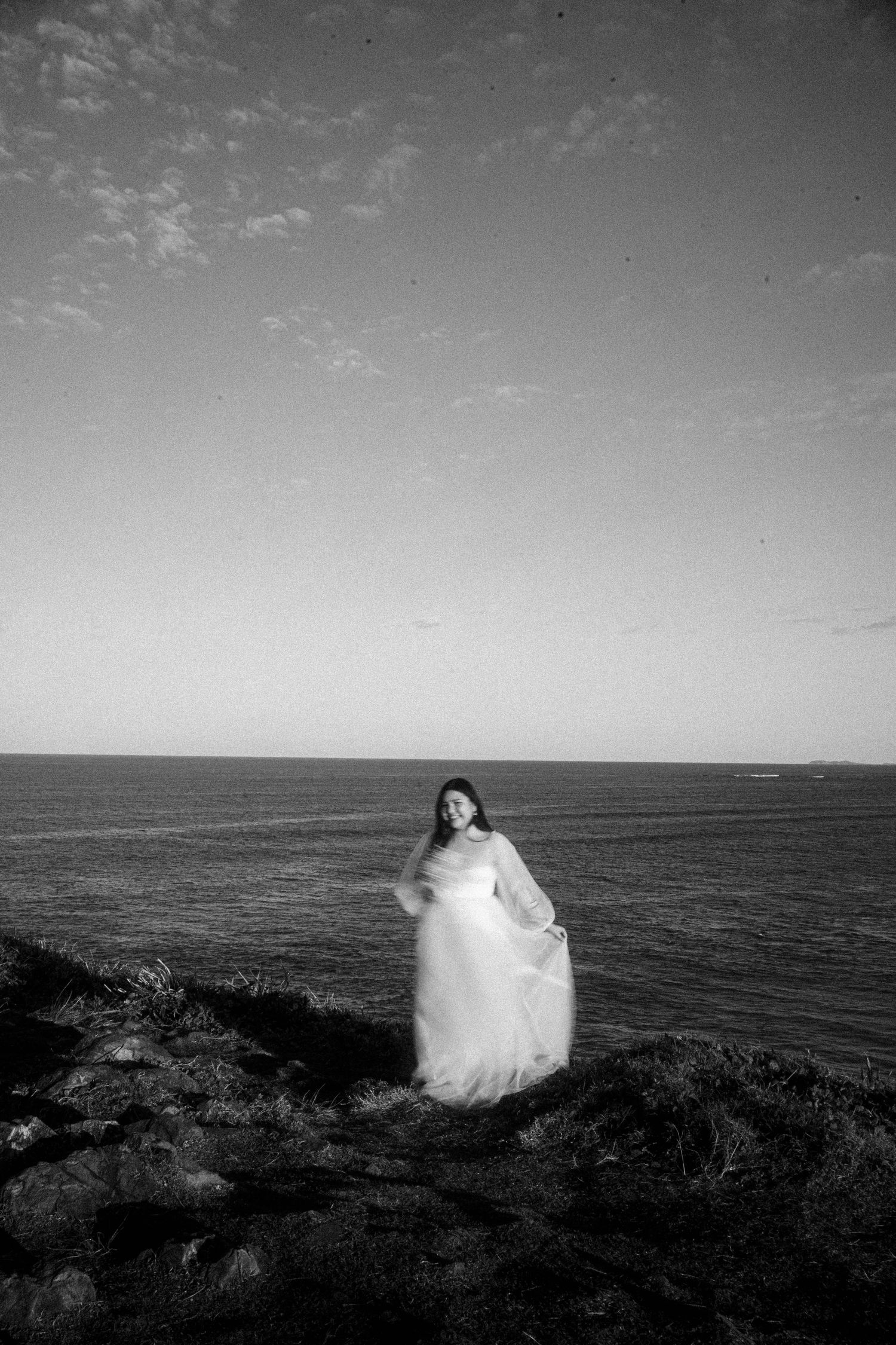 A series of black and white coastal photographs showing a white ethereal figure moving against an ocean horizon.