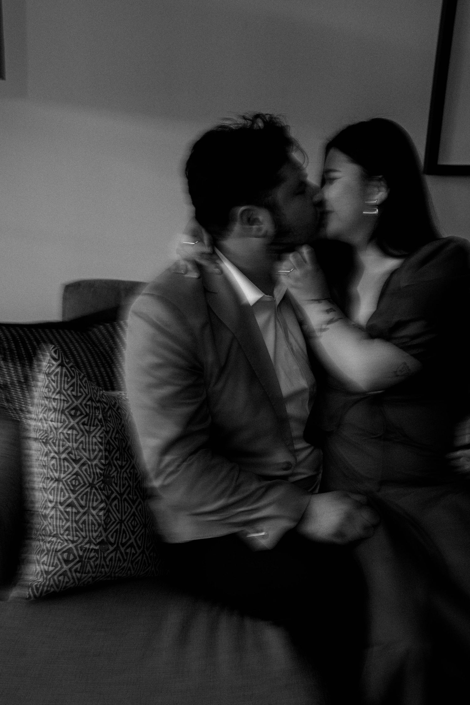 A series of black and white photos showing two people in an intimate moment on a couch with a patterned pillow.
