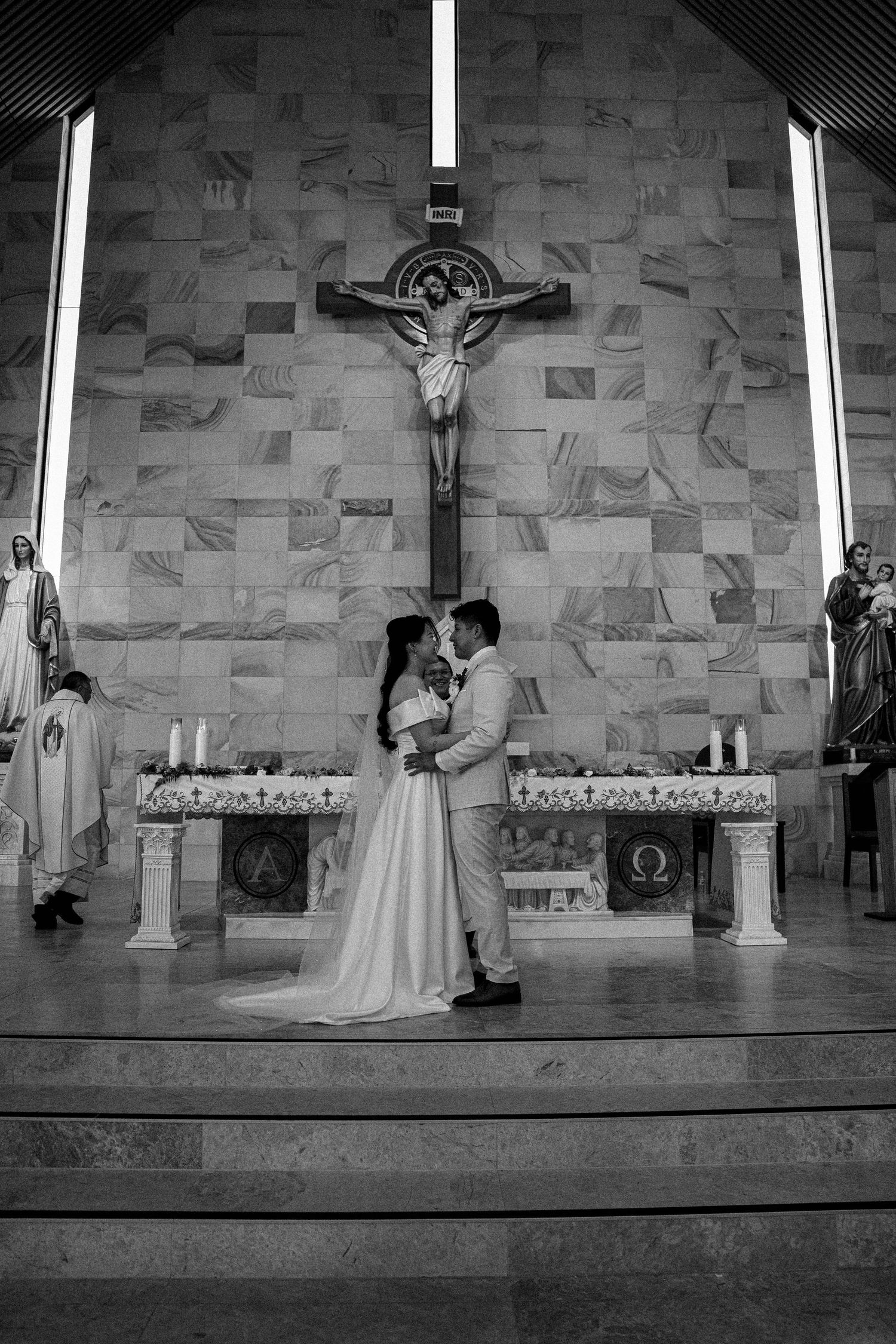 A series of black and white wedding ceremony photos showing a couple at the altar in a stone church.