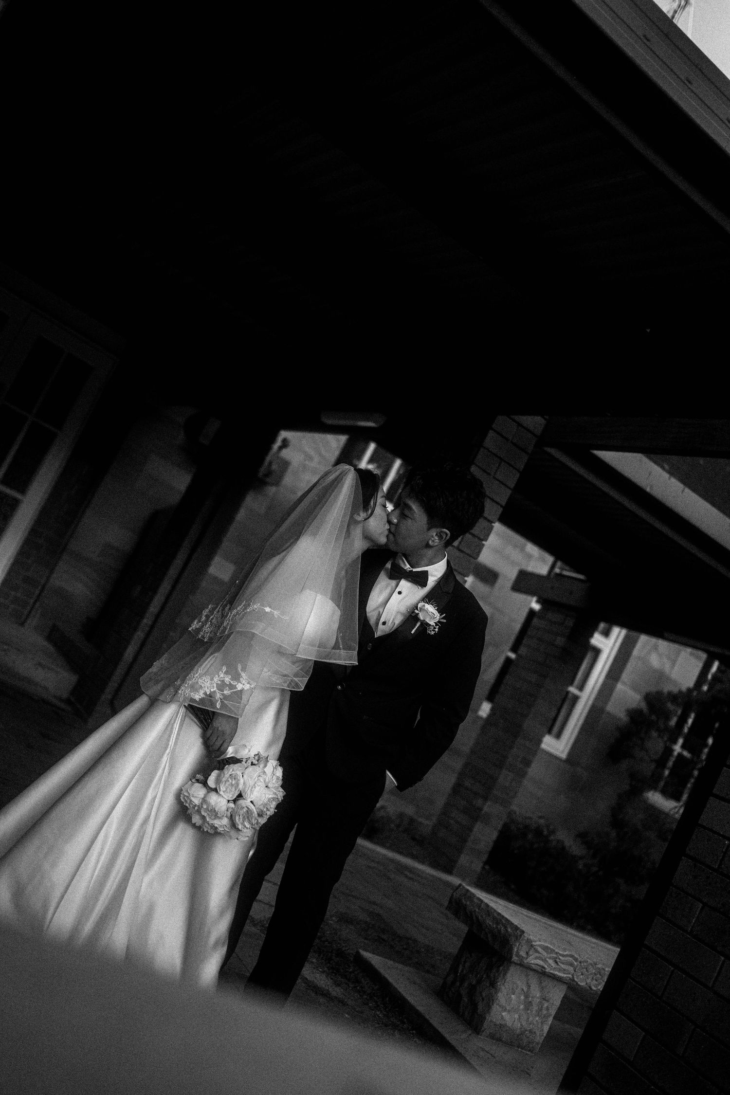 Black and white wedding photo sequence showing a couple in formal attire walking together in a dimly lit venue.