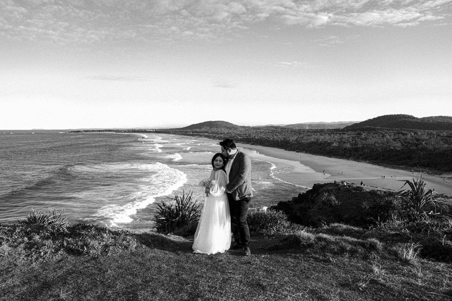 Panoramic black and white coastal landscape with dramatic cliffs overlooking the ocean and cloudy sky.