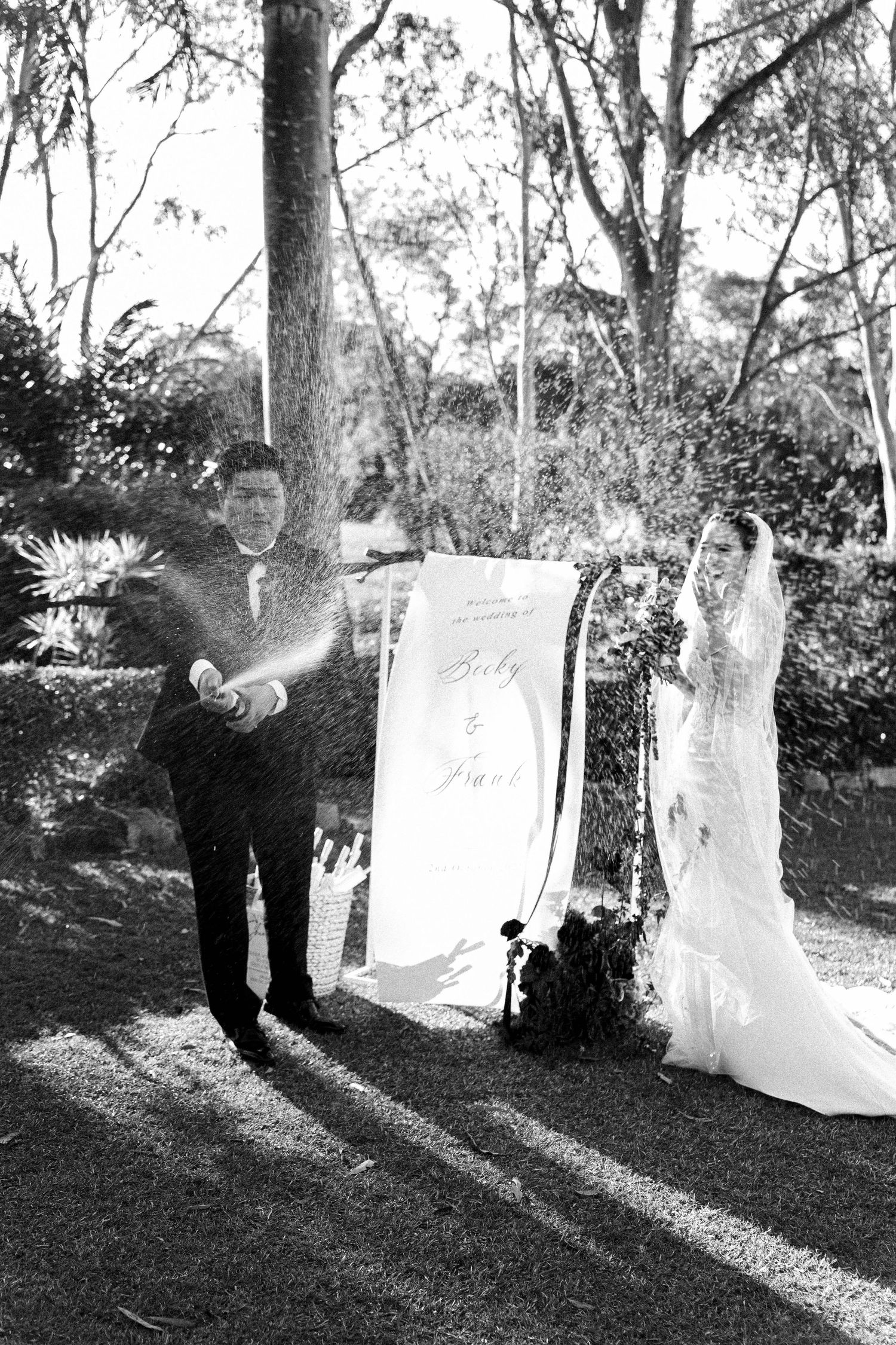 Black and white photo sequence showing a couple dancing and twirling with white sheets in a sunlit outdoor garden setting.