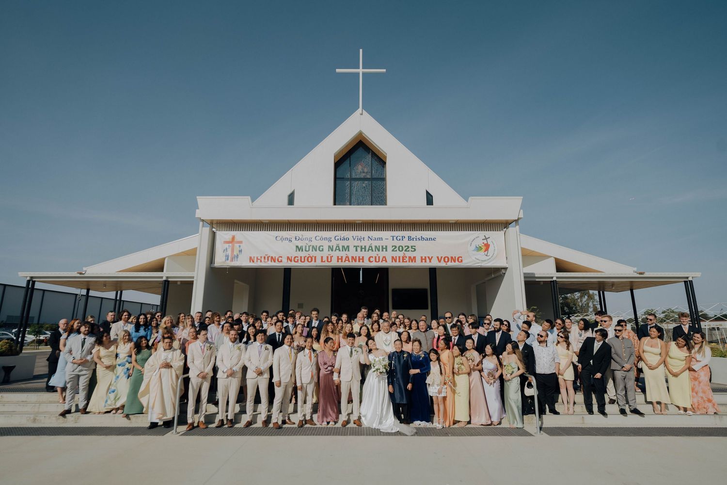 A panoramic collage of wedding party photos taken outside a modern white church with a cross on top.