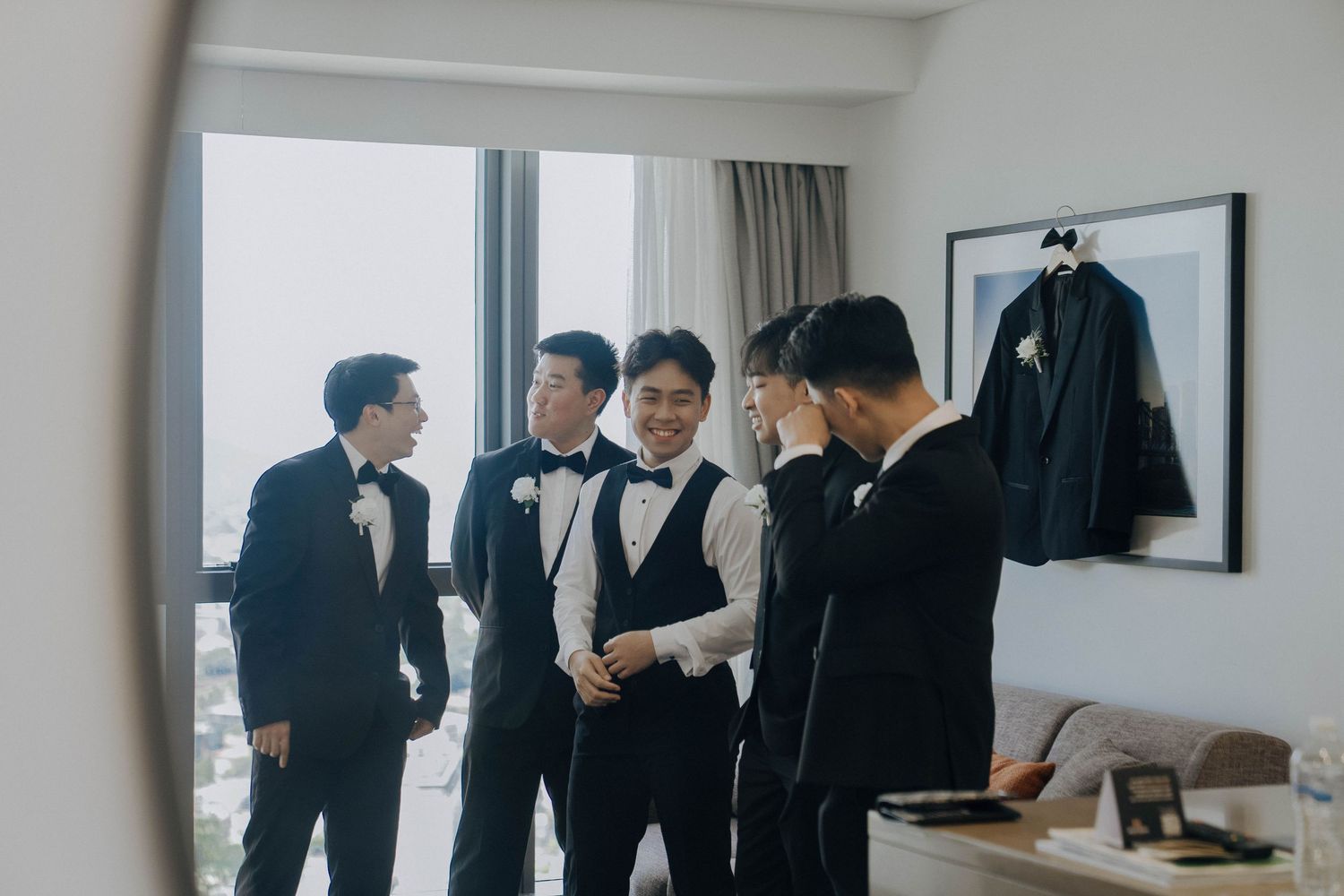 Business professionals in dark suits gather in a modern office space for a meeting or discussion.