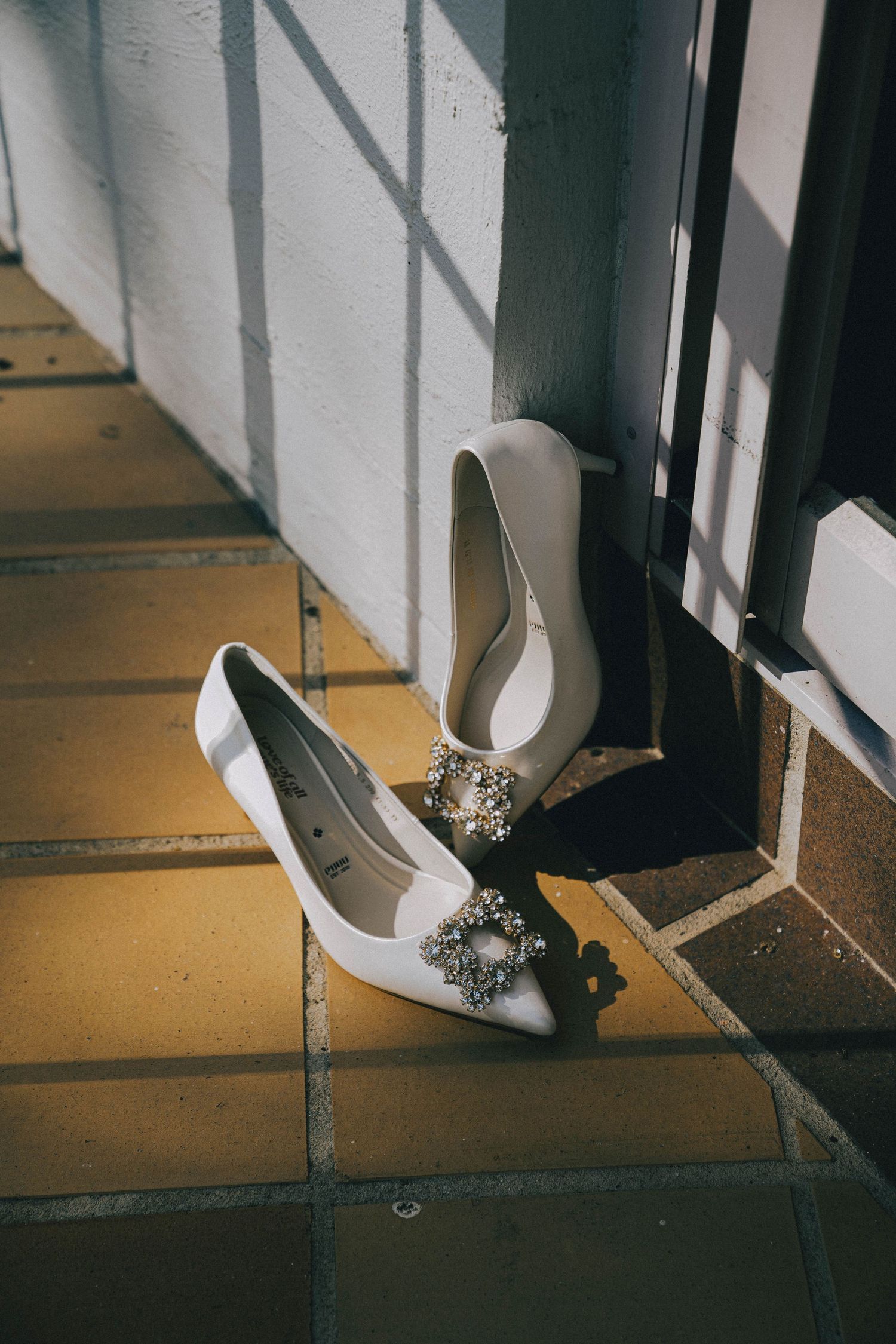 A sequence of four photos showing a white high heel shoe stepping on and crushing a cigarette on a tiled floor.