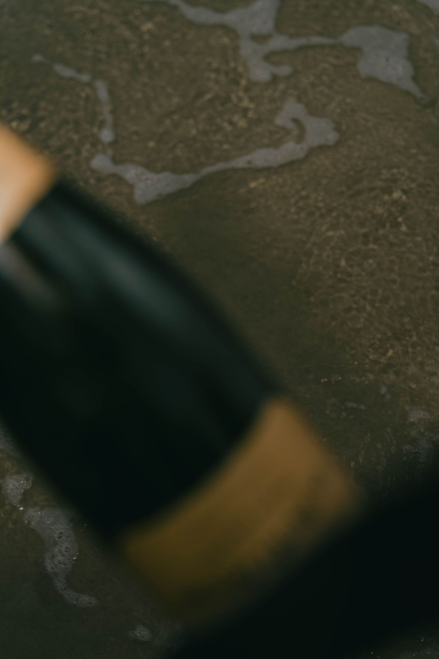 Dark leather gloves with contrasting tan accents rest on a textured gray surface.