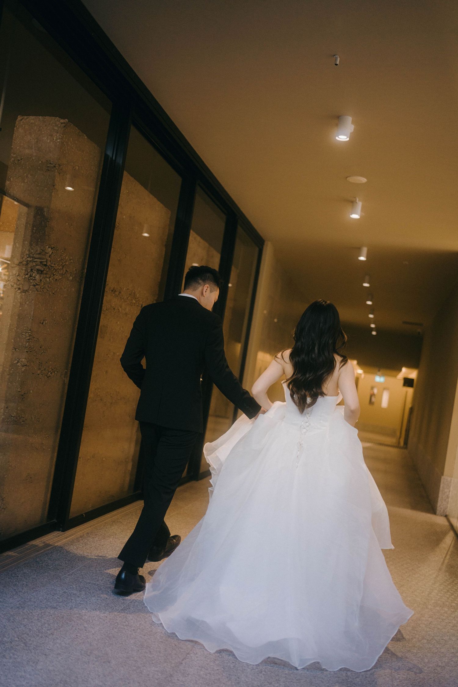 A sequence of photos showing a white wedding dress flowing down a dimly lit hotel hallway.