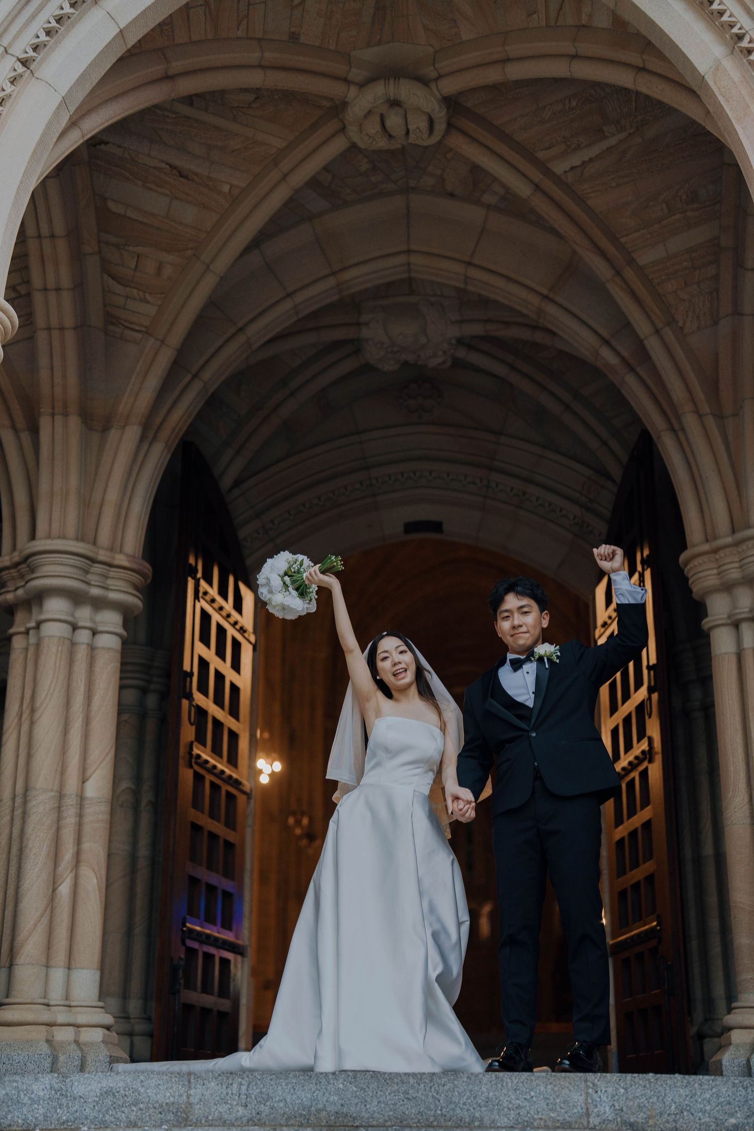 Elegant wedding couple poses under stone archways at historic venue in dramatic sequence of candid moments.