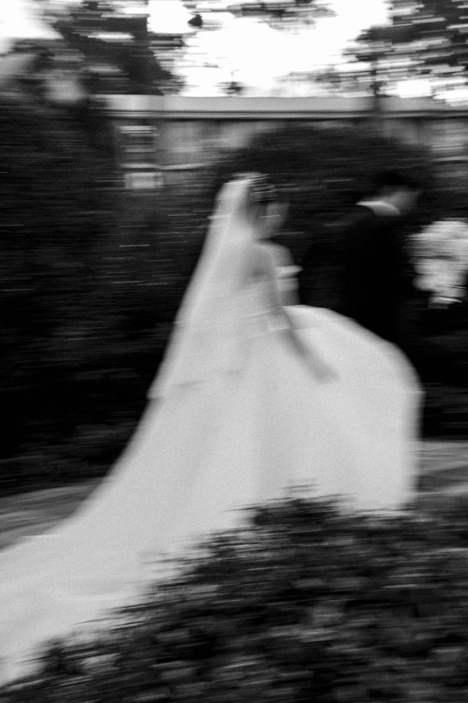 A blurred black and white motion sequence shows a ghostly figure in white moving across a dark background.