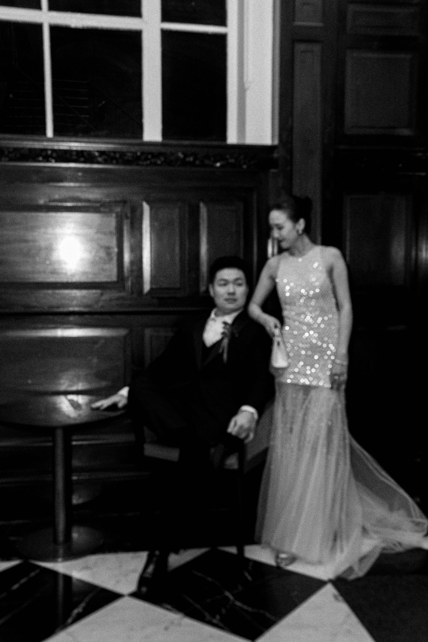 A sequence of black and white photos showing someone in a light-colored dress twirling and dancing in a dark room.