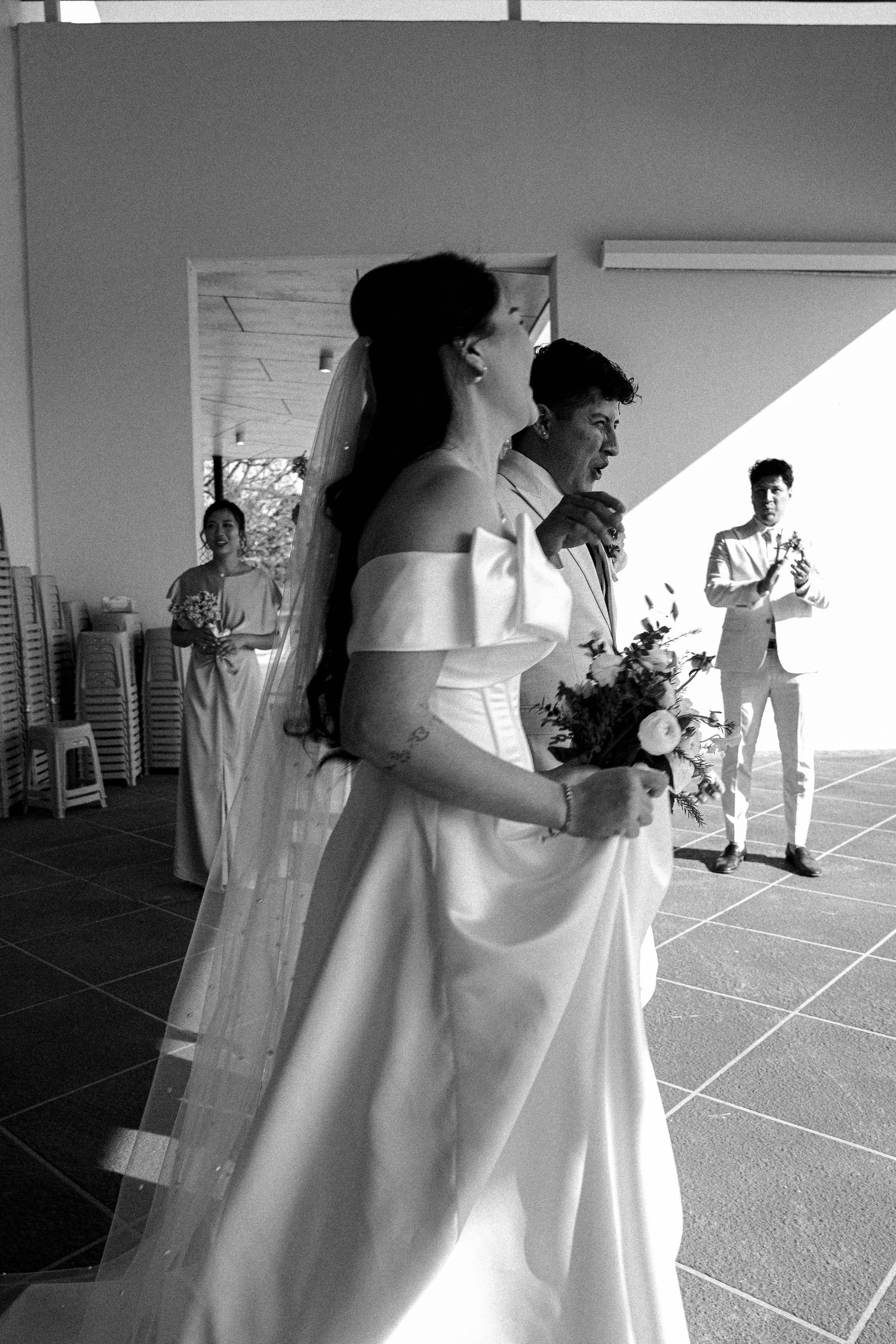 A black and white photo series showing a bride getting ready with her bridal party in a sunlit room.