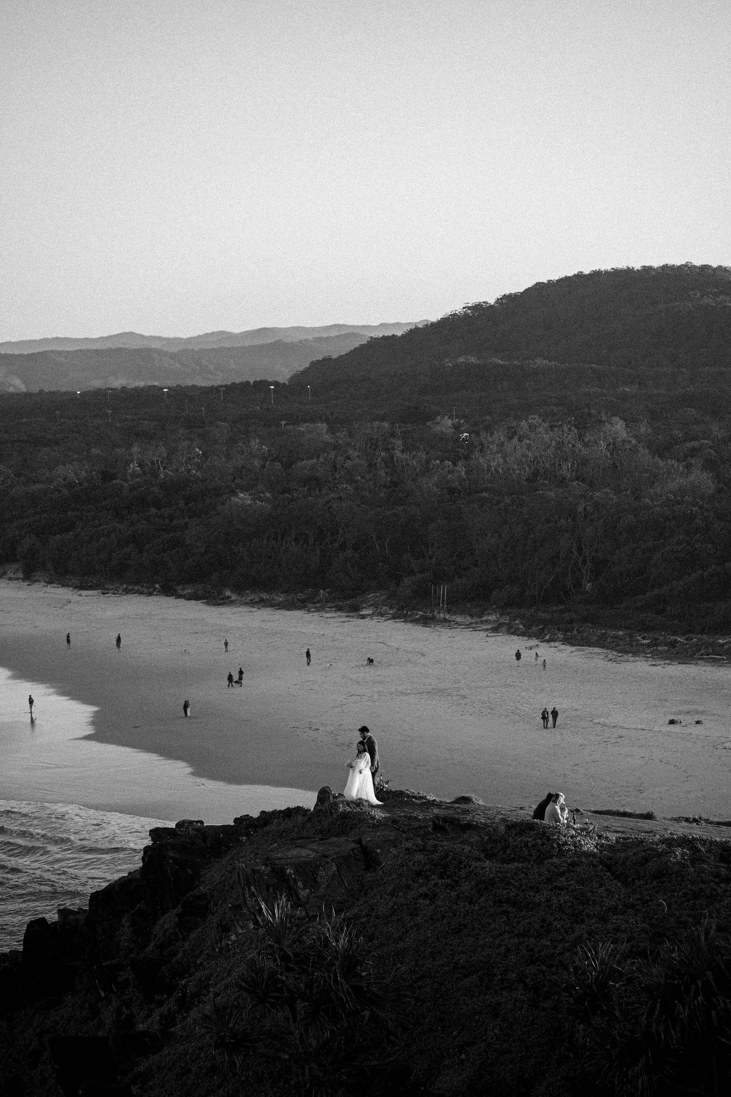 A black and white photo sequence shows figures walking along a misty beach with hills in the background.