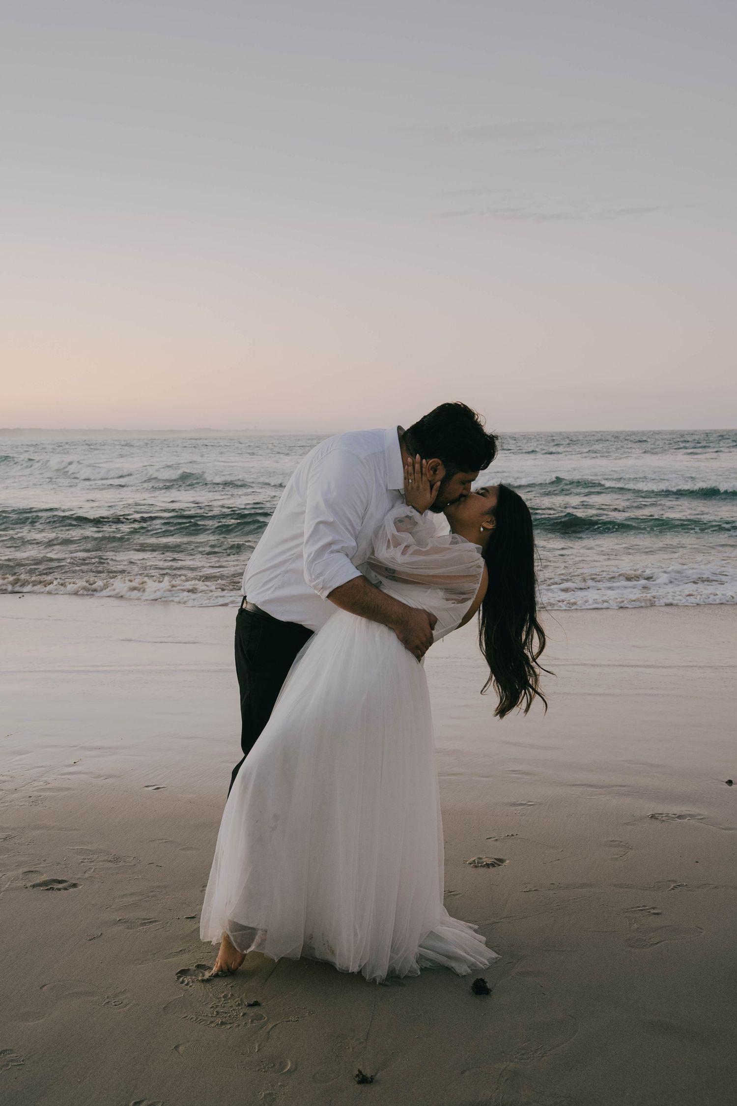 A romantic beach wedding photo sequence shows a couple in white embracing and dipping on the sandy shore at sunset.
