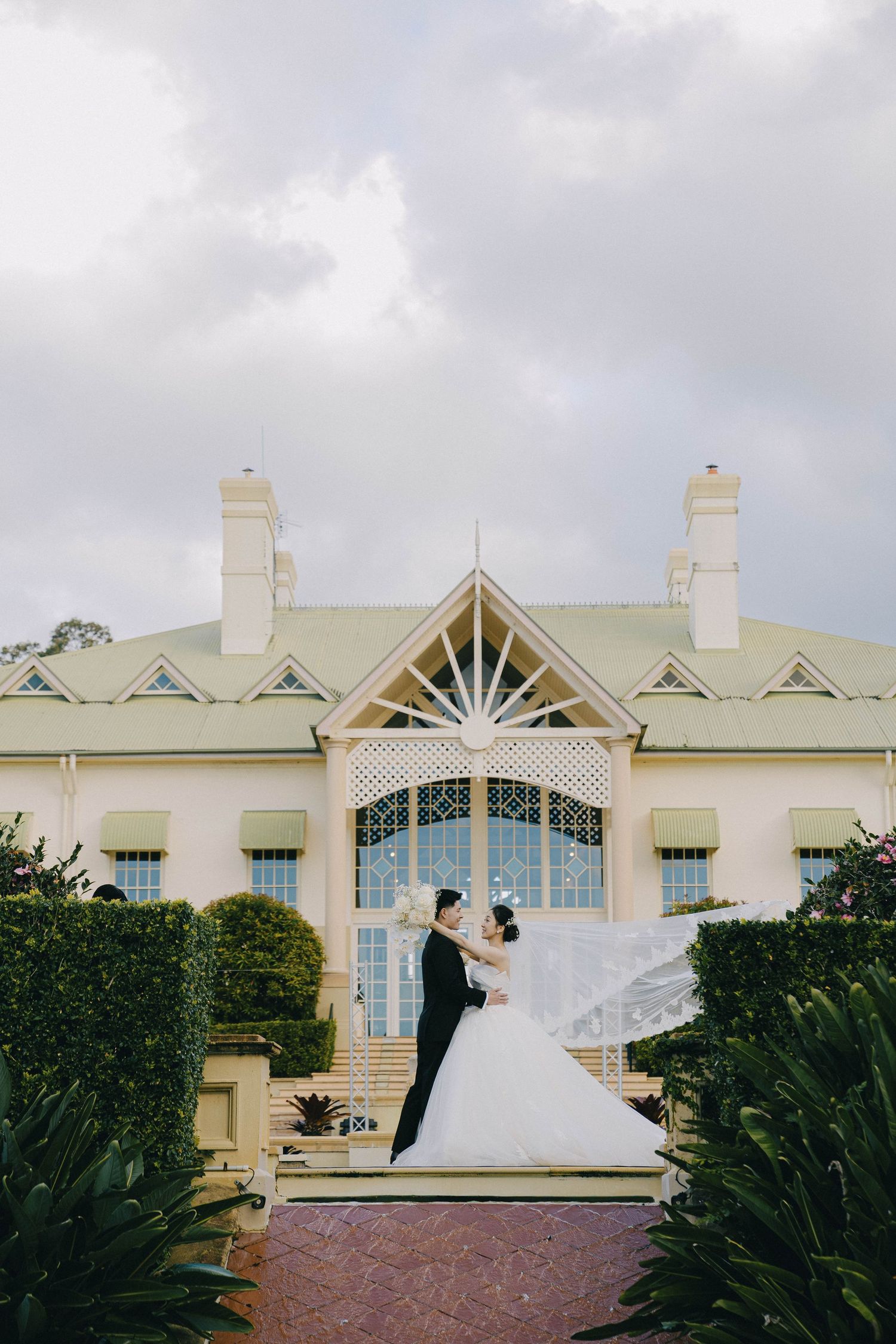 A series of architectural shots showing a white wedding venue building with elegant windows and peaked roofs against a cloudy sky.