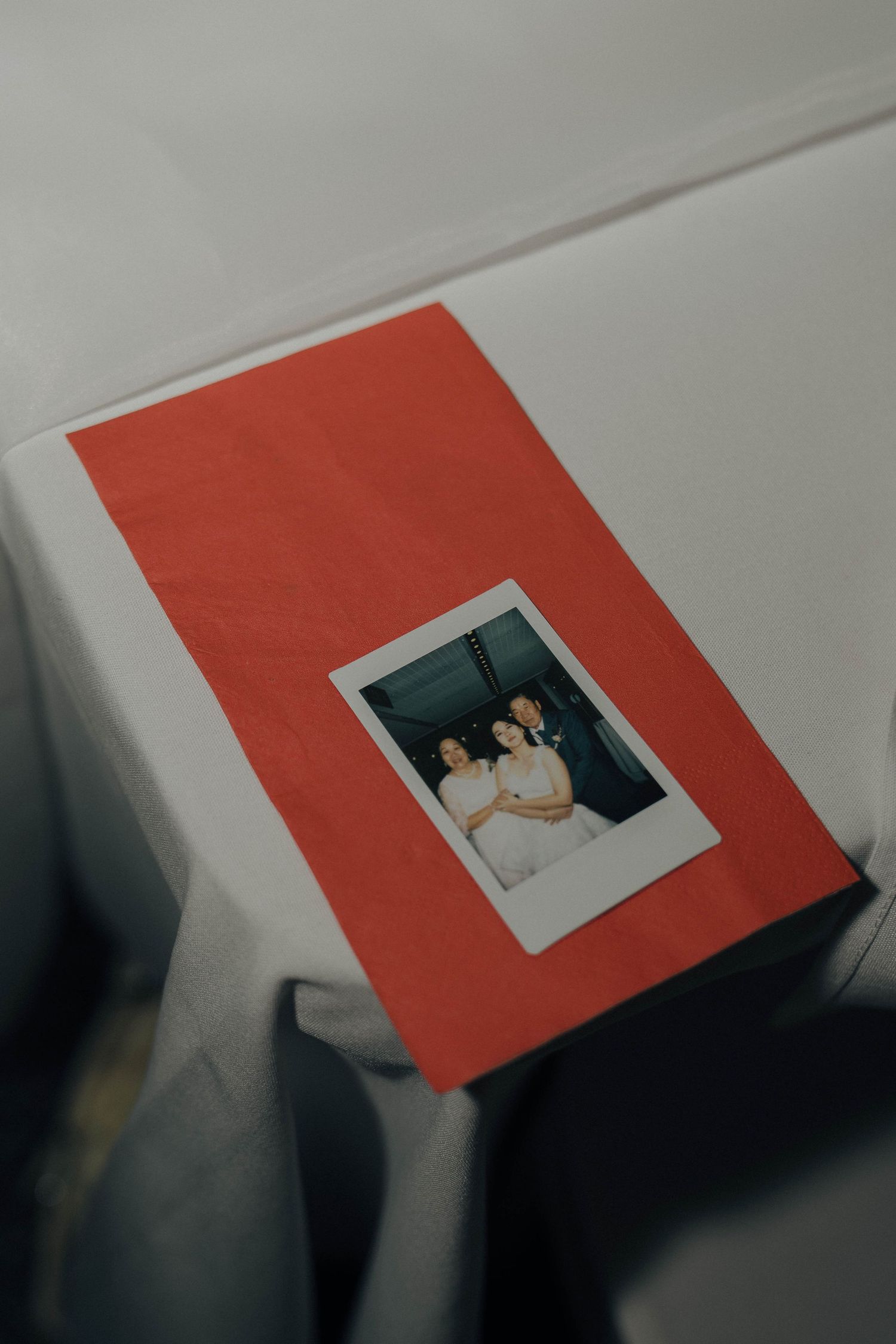 A series of four connected images showing a Polaroid photo placed on a red and white surface from different angles.