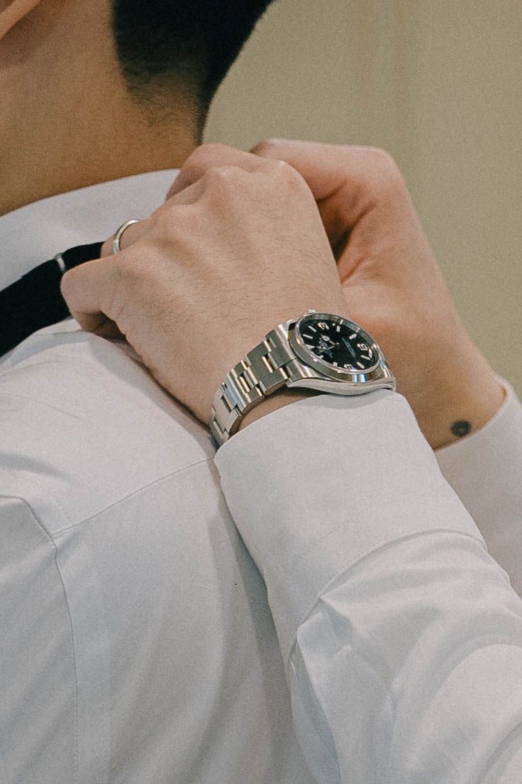 Close-up view of a silver watch on a person's wrist wearing a white dress shirt sleeve.
