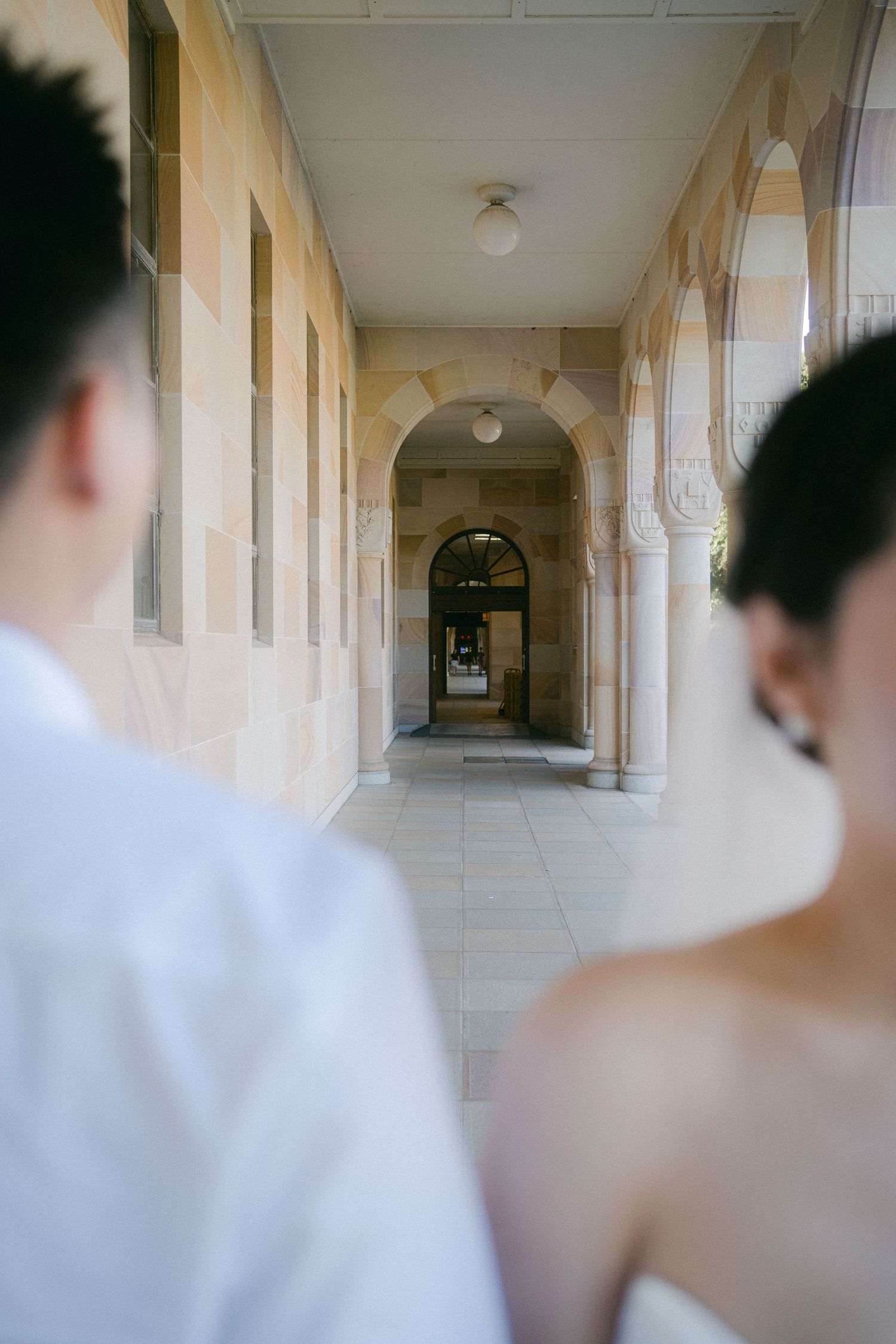 A series of architectural hallway photos showing progressively blurred white pillars and arched walkways in a historic building.