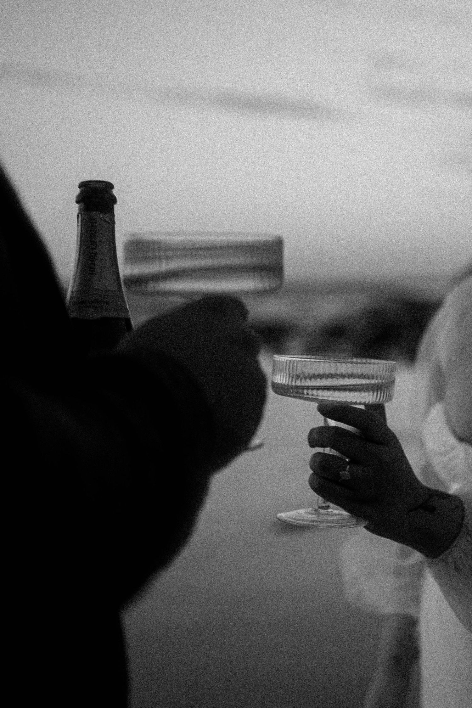 A black and white photo sequence showing hands opening a bottle cap in progressive stages of motion.