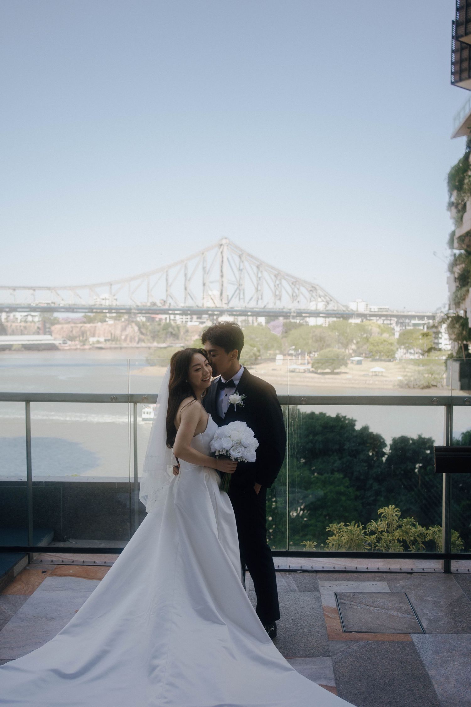 A couple shares a romantic moment on a terrace overlooking the Jacques Cartier Bridge in Montreal.