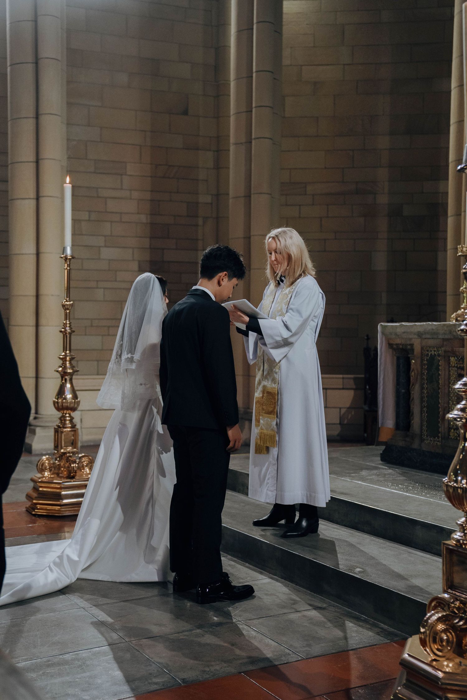A series of four photos showing a wedding ceremony taking place in a church hallway with stone walls and candelabras.