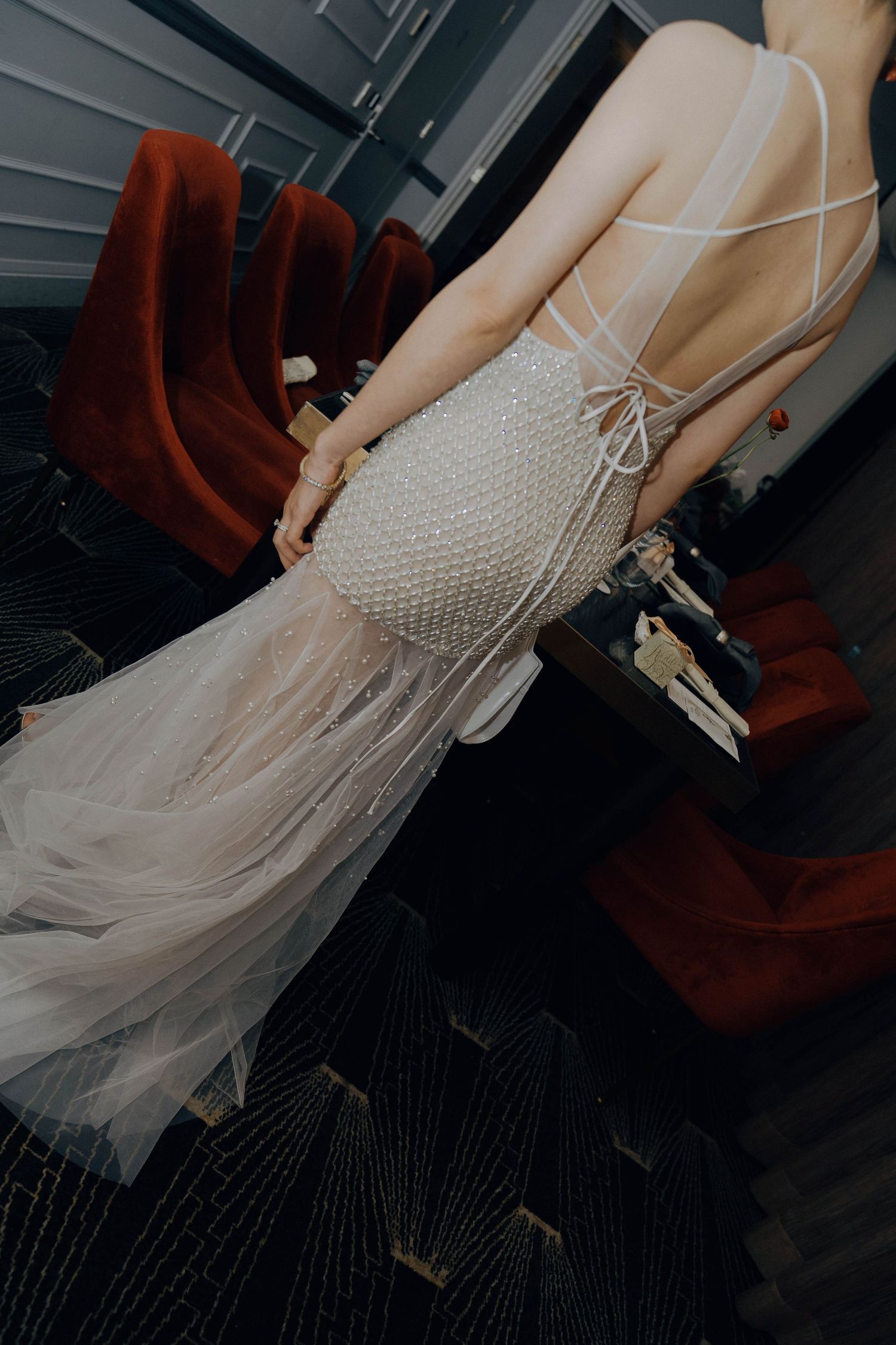 Close-up views of a flowing tulle wedding dress with delicate beaded details on the bodice shown from different angles.
