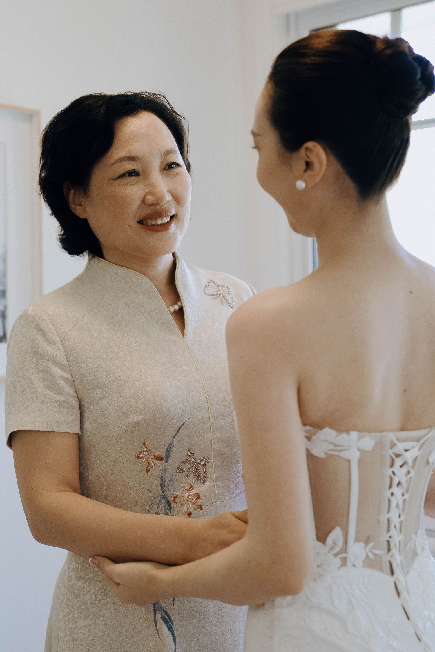 A series of photos showing a bride getting ready in a white wedding dress with corset-style back details.