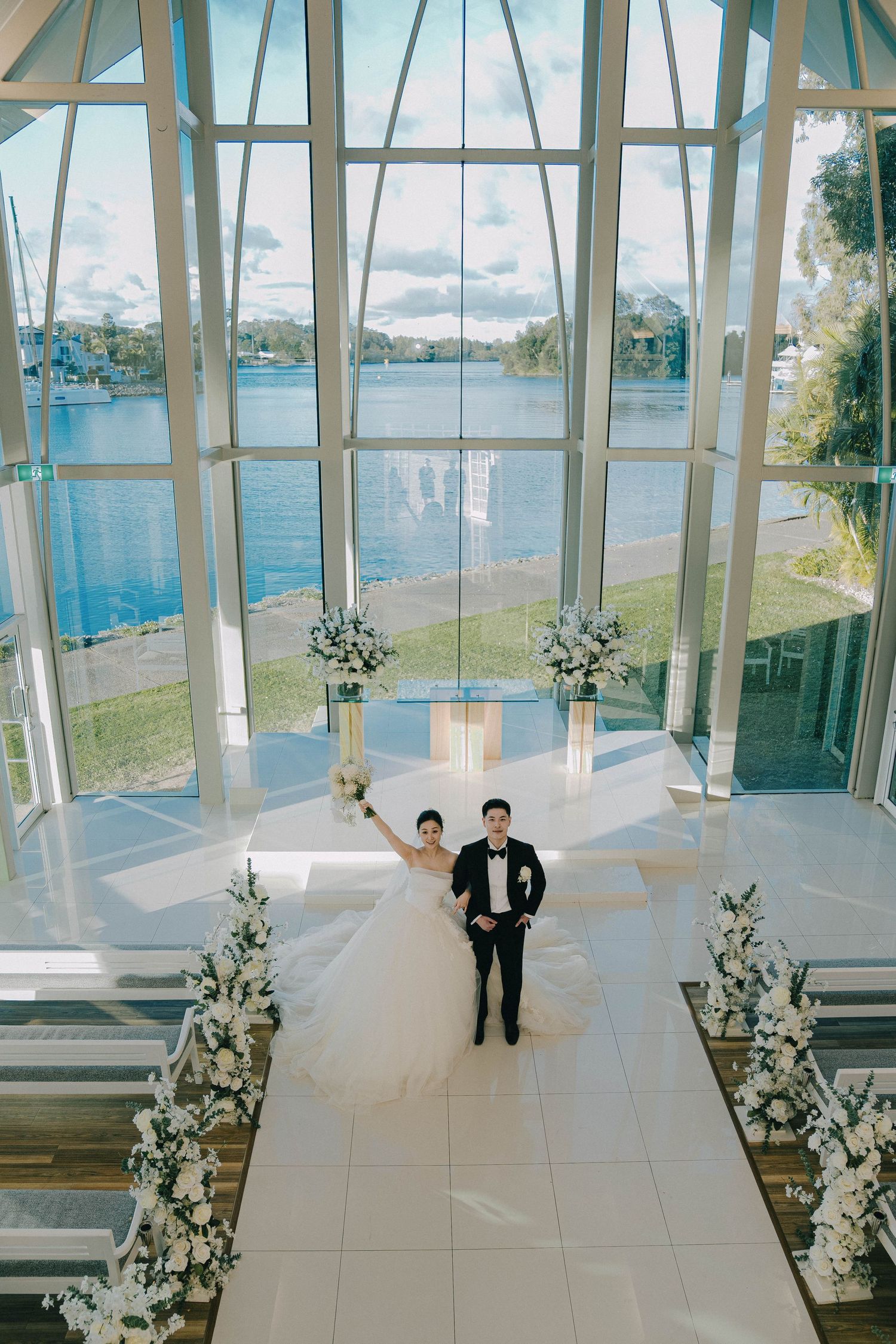 A series of photos showing a wedding couple in a modern glass chapel overlooking a waterfront view.