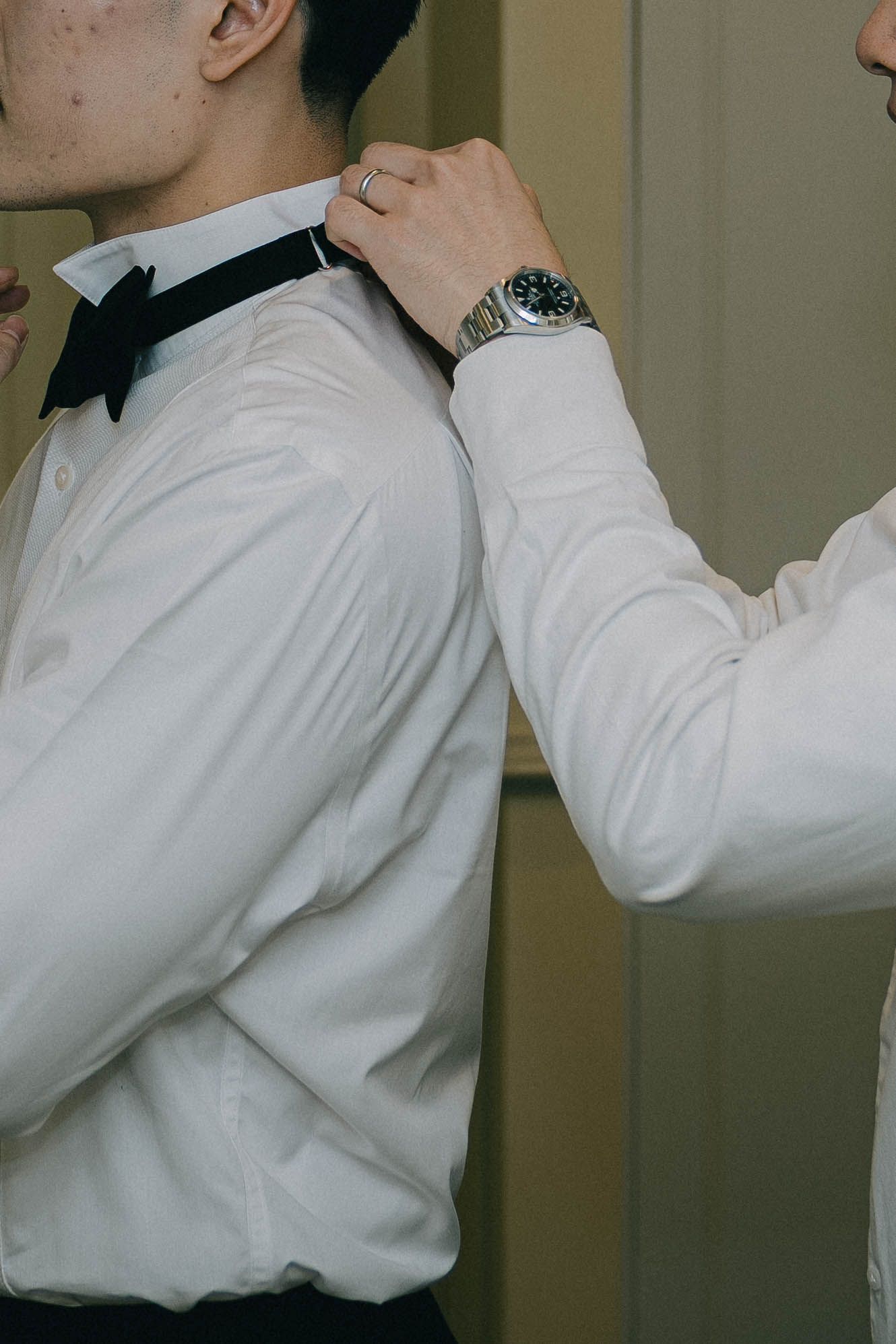 Person wearing a white dress shirt adjusts their collar in a sequence of cropped photos.