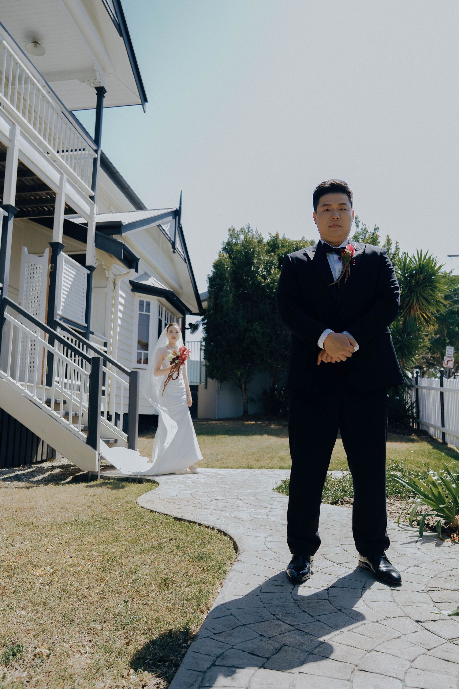A series of cropped photos showing black dress shoes and formal pants on a stone walkway outside a white building.