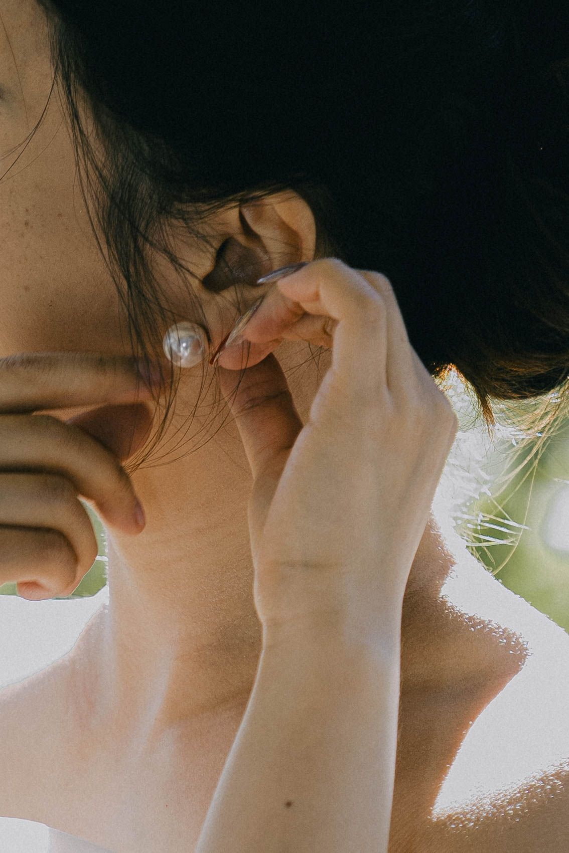 Close-up profile view of a person's neck and jawline against a bright background.