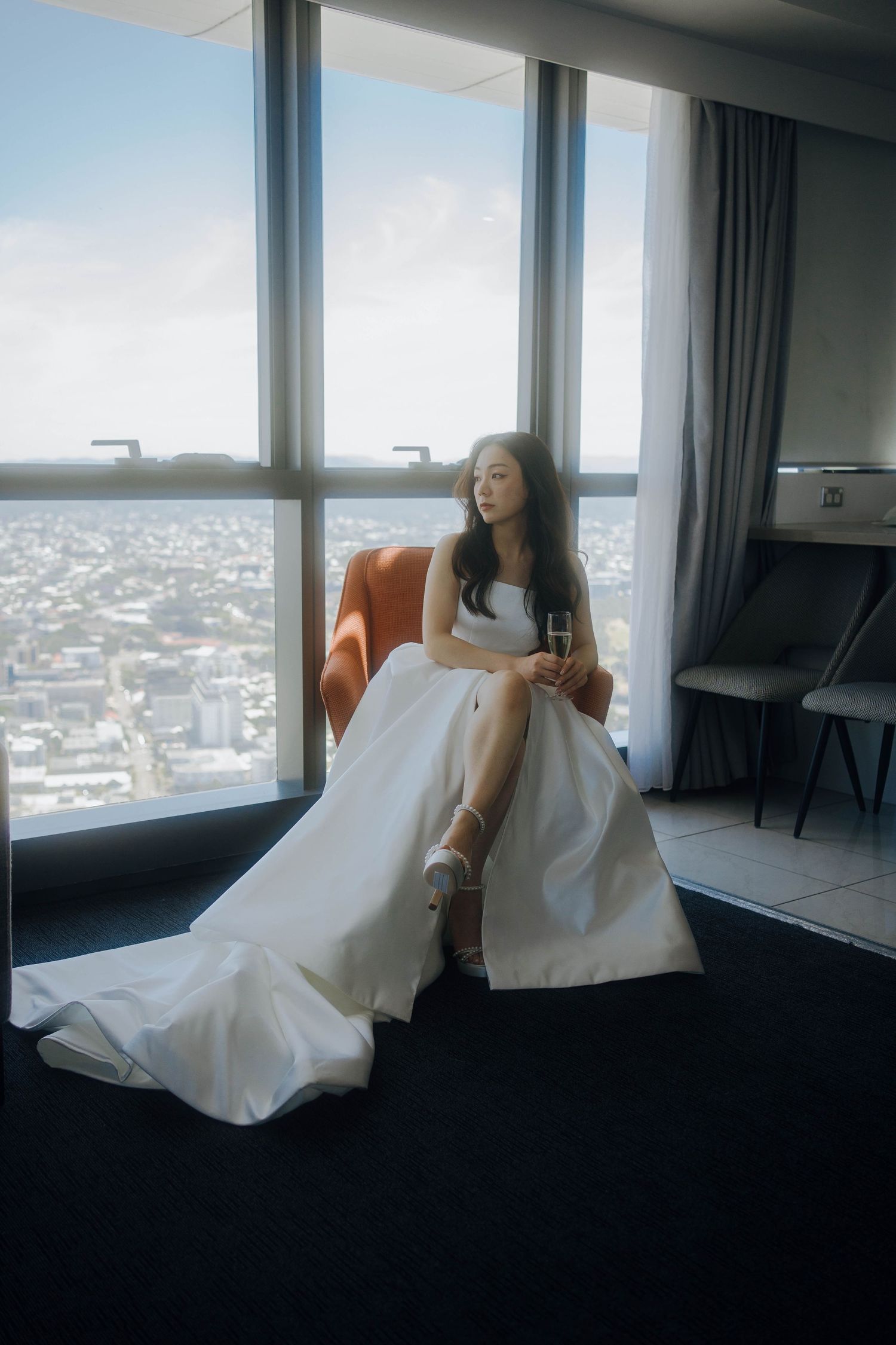 A series of artistic shots showing white bedding against large windows with a cityscape view in a modern hotel room.