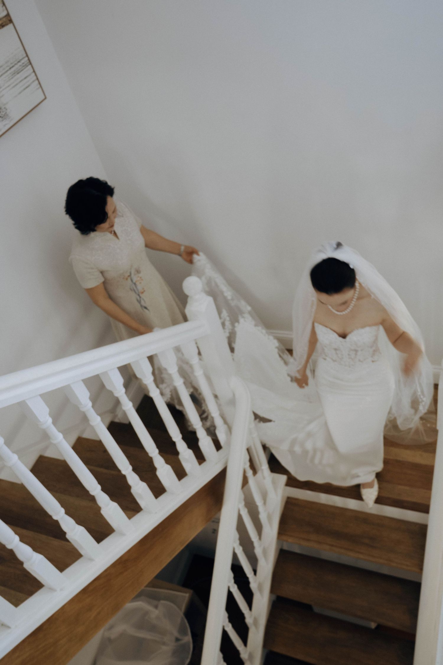 A sequence of images showing someone in white clothing descending a staircase with white railings against a light wall.