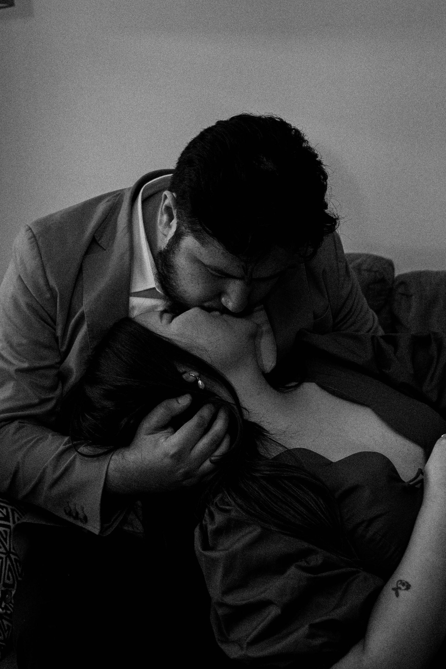 Black and white intimate portrait of a tender romantic moment between two people lying close together.