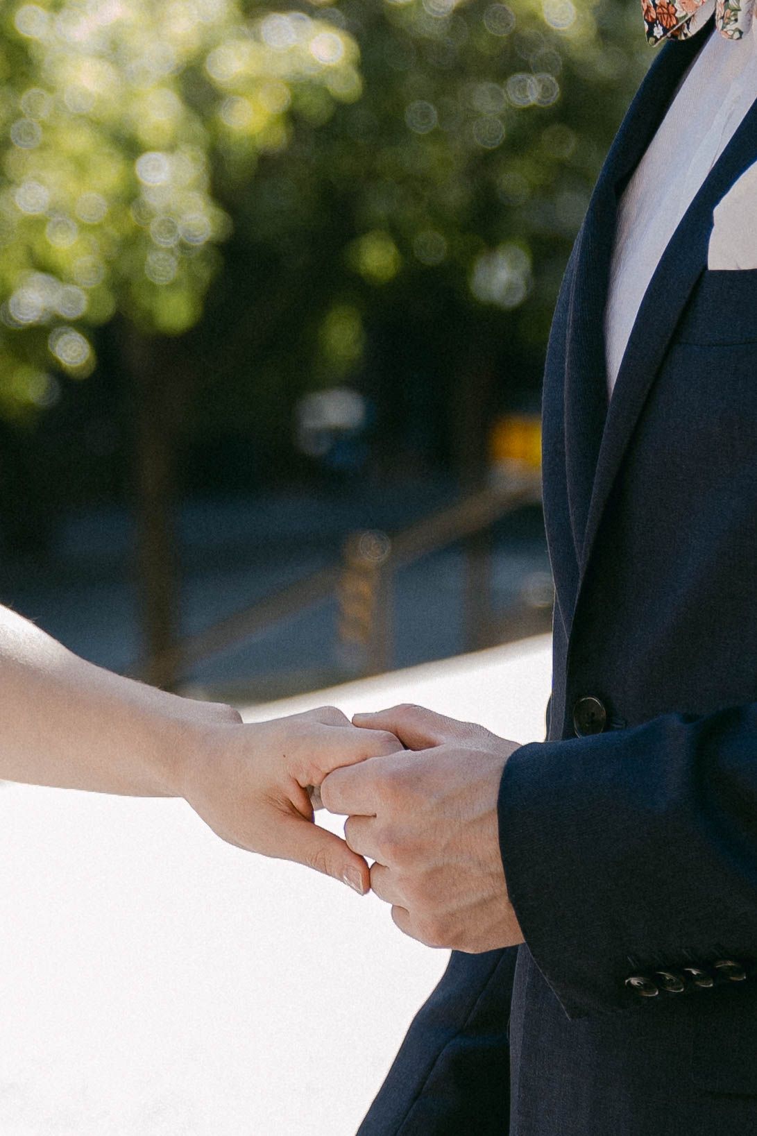 Close-up of two people in business suits exchanging or reviewing documents outdoors.