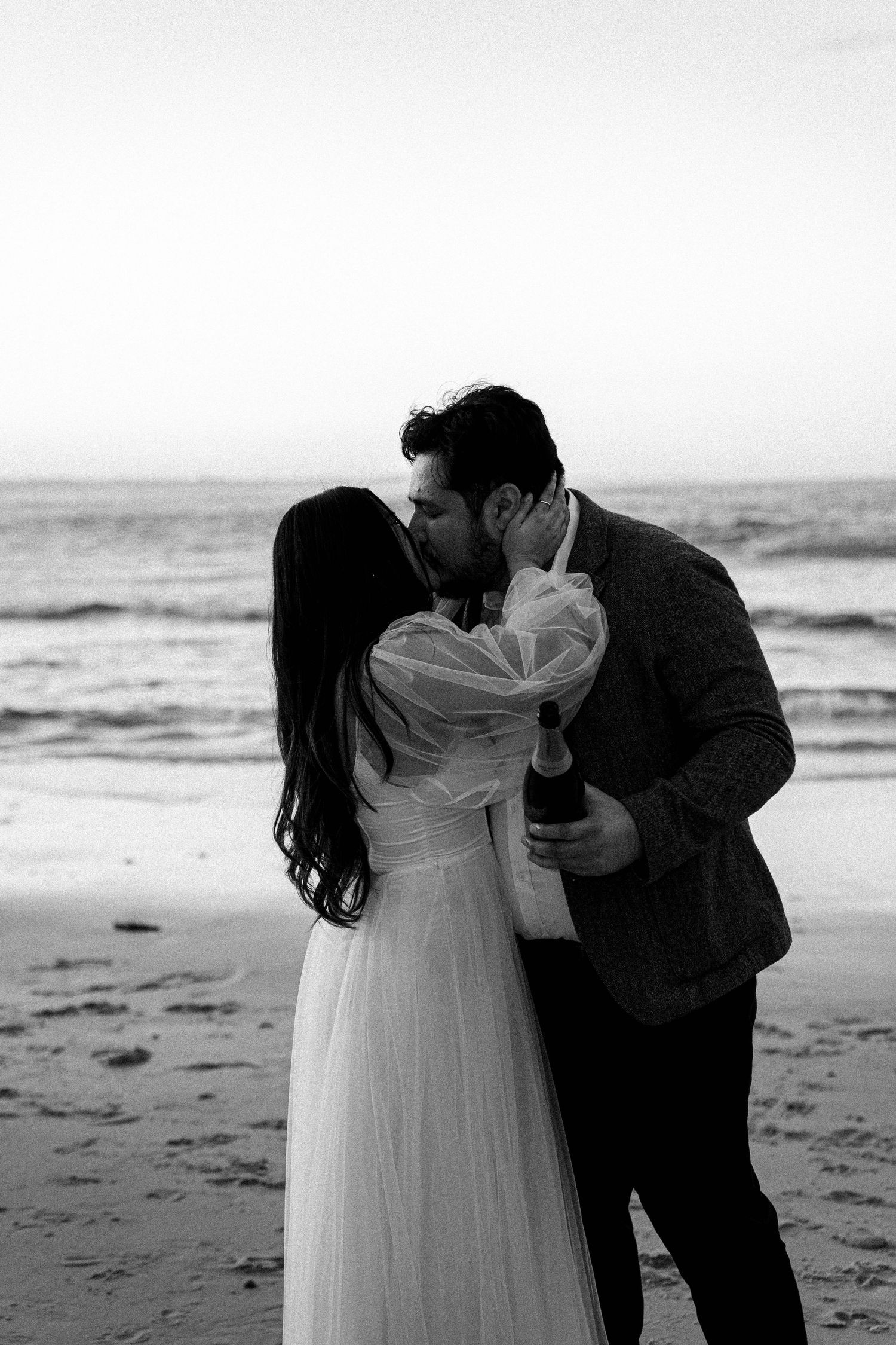 A romantic black and white photo sequence shows a couple embracing on a beach at sunset.