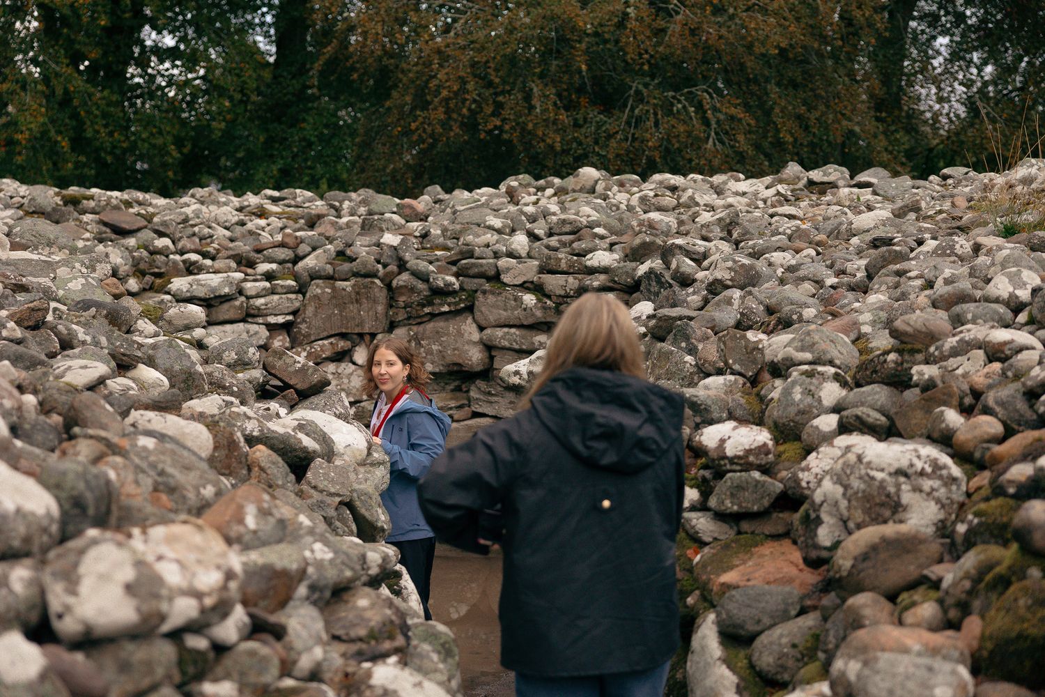 Girls walking in stone formation in Clava Cairns Scotland.