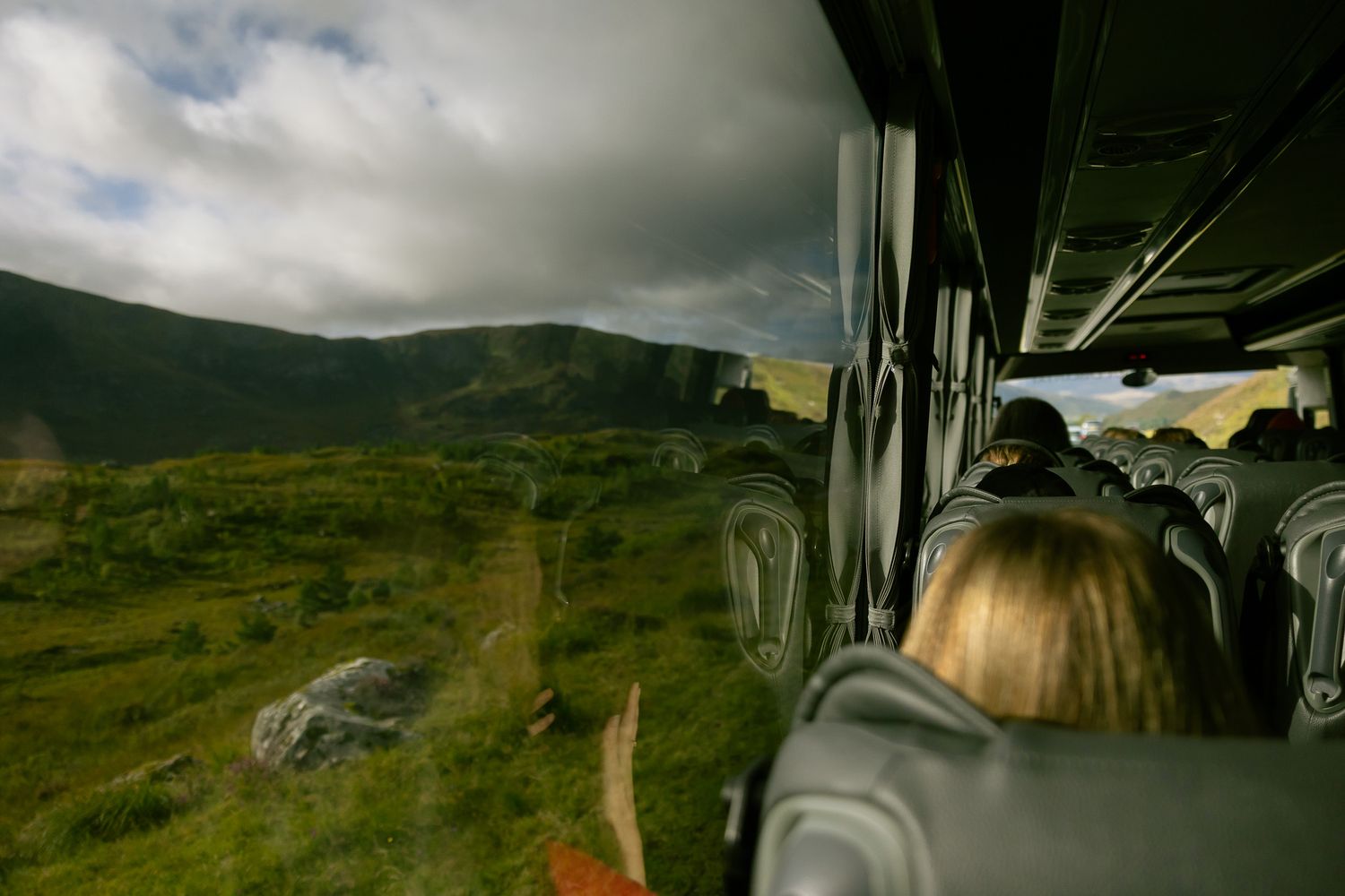 Inside tour bus driving through Scottish Highlands.